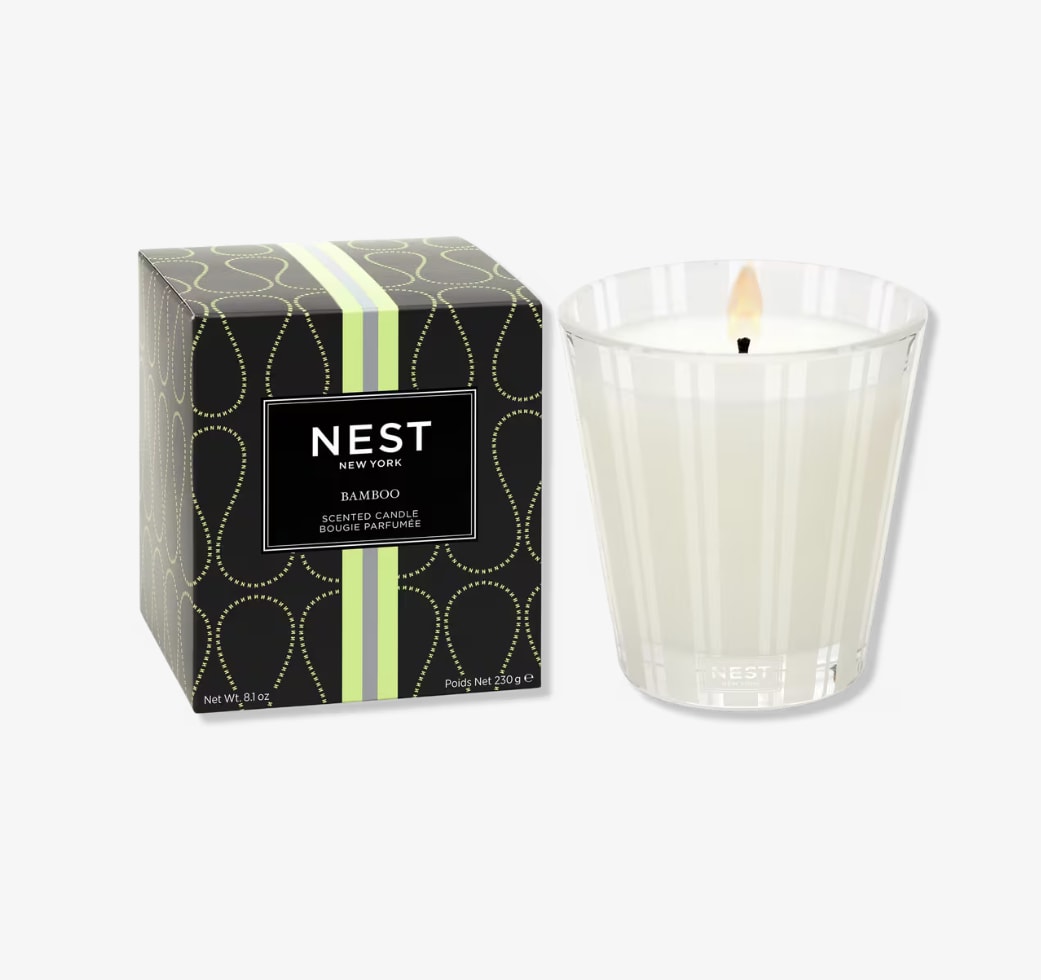 Scented candle in a glass holder beside its box