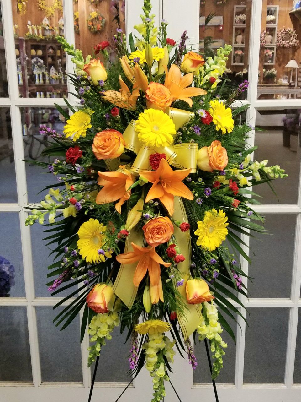 Large standing spray with orange lilies, yellow daisies, and roses