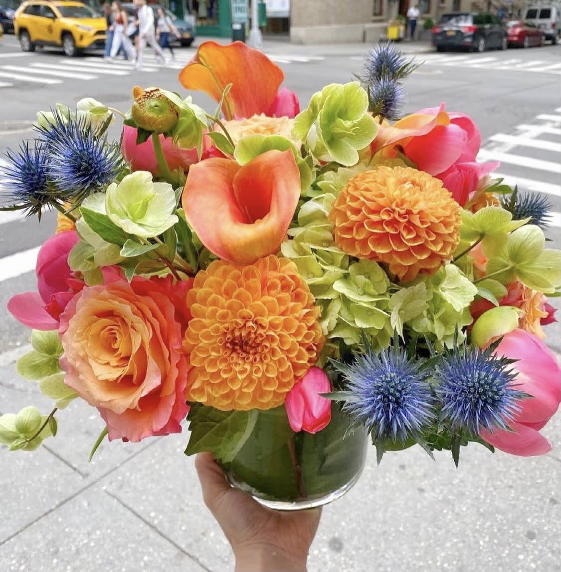 Bright bouquet of orange, pink, and green flowers in a glass vase