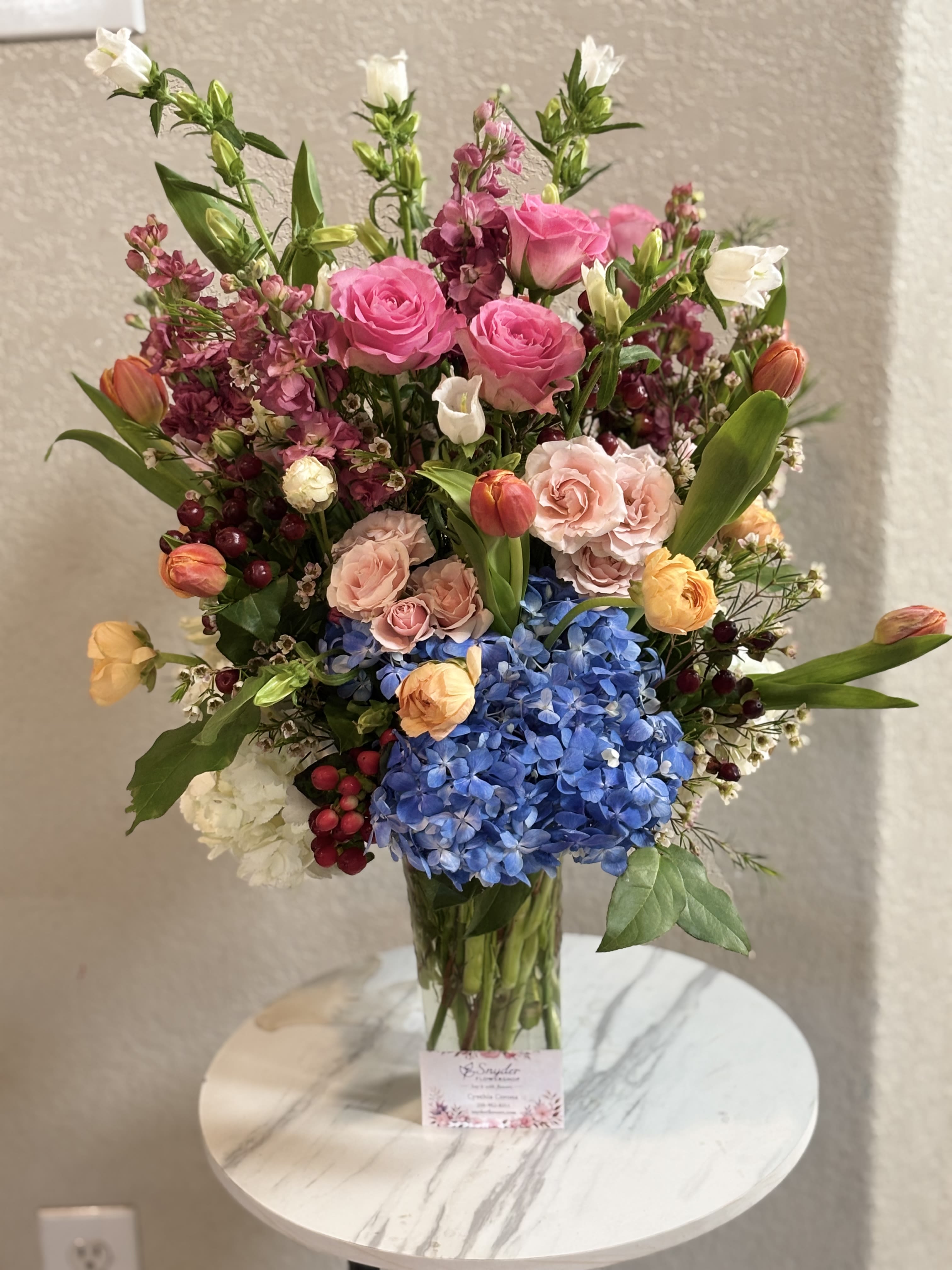 Royal Garden Bloom - Luxury flower arrangement handcrafted with premium blue hydrangeas, pink roses, tulips, ranunculus and fresh seasonal flowers by Snyder Flowers in San Antonio. This elegant floral bouquet is designed with vibrant colors and luxury garden style perfect for birthdays, anniversaries, congratulations, Mother’s Day and special occasions. Our San Antonio florist specializes in fresh premium flower arrangements, custom bouquets, same day flower delivery and elegant floral designs made with high quality flowers and exceptional attention to detail. Snyder Flowers proudly creates handcrafted luxury flower bouquets with fresh roses, hydrangeas and tulips for customers looking for beautiful floral arrangements, reliable same day delivery and affordable luxury flowers in San Antonio.