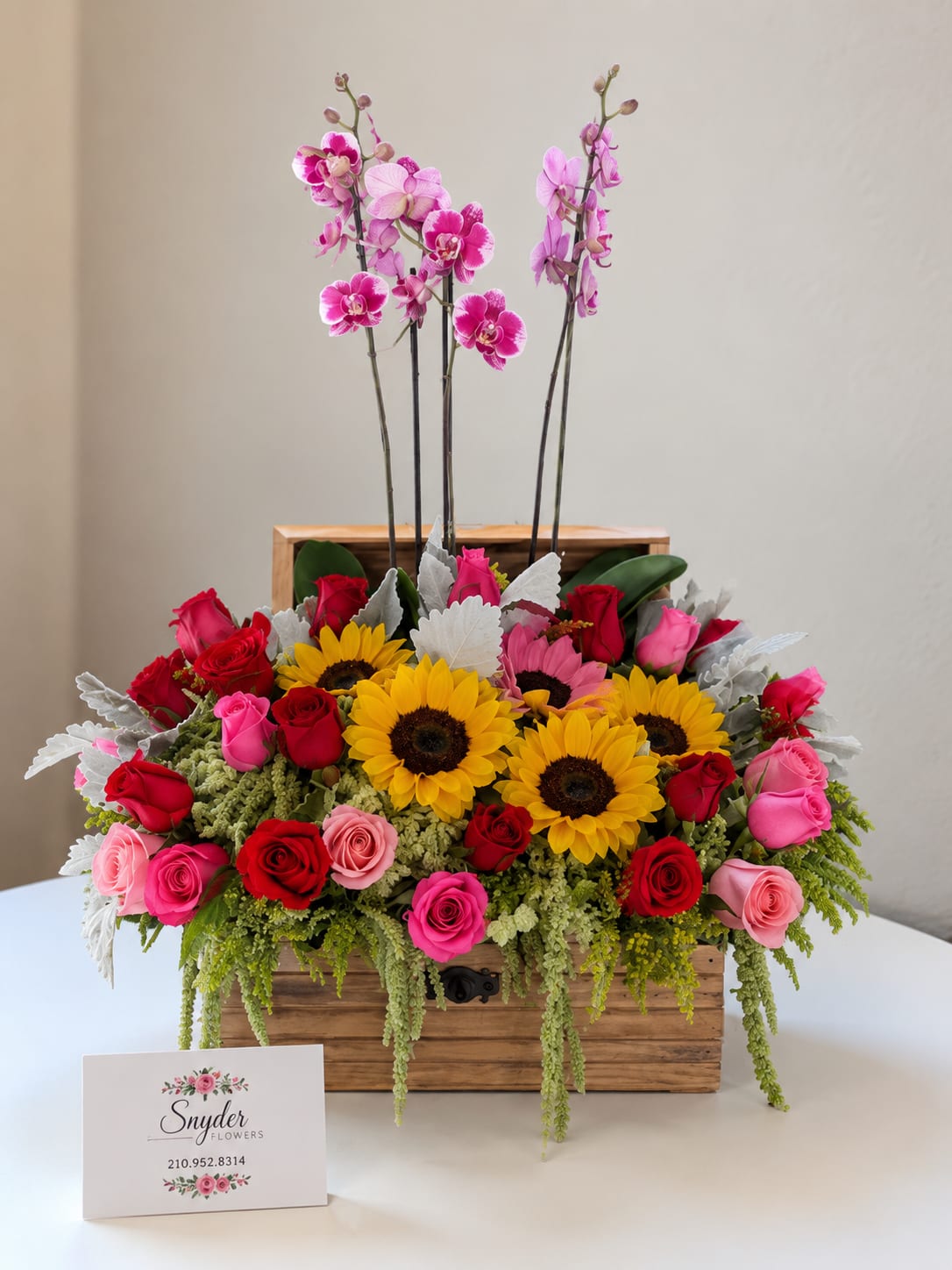 Wooden box arrangement with roses, sunflowers, and pink orchids