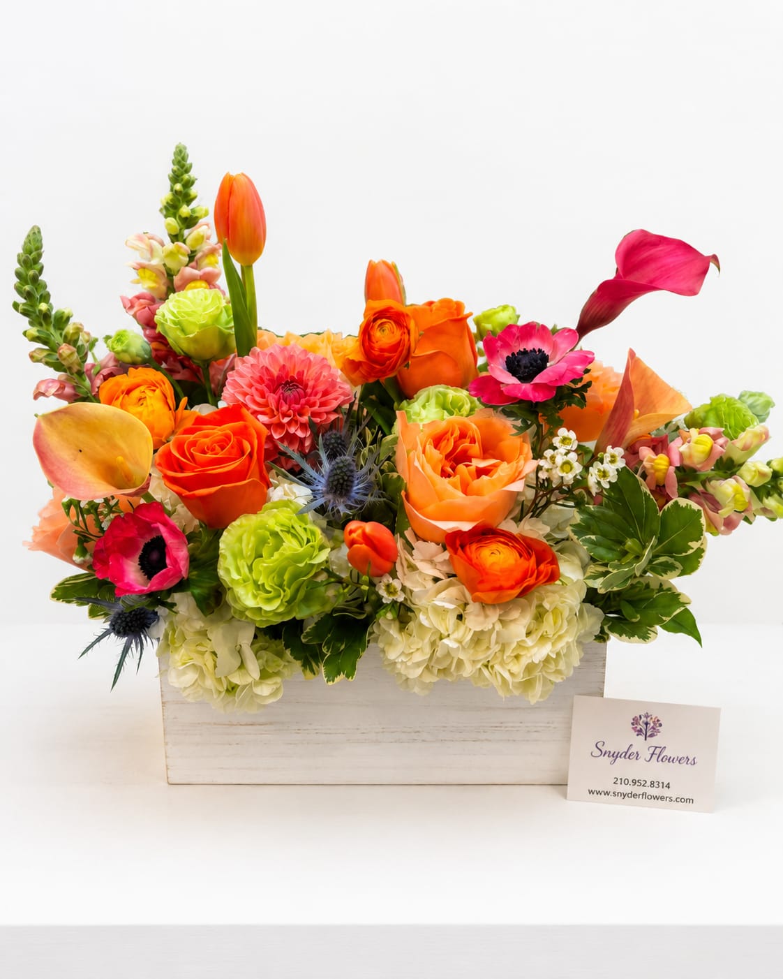 Bright mixed flower arrangement in a white wooden box