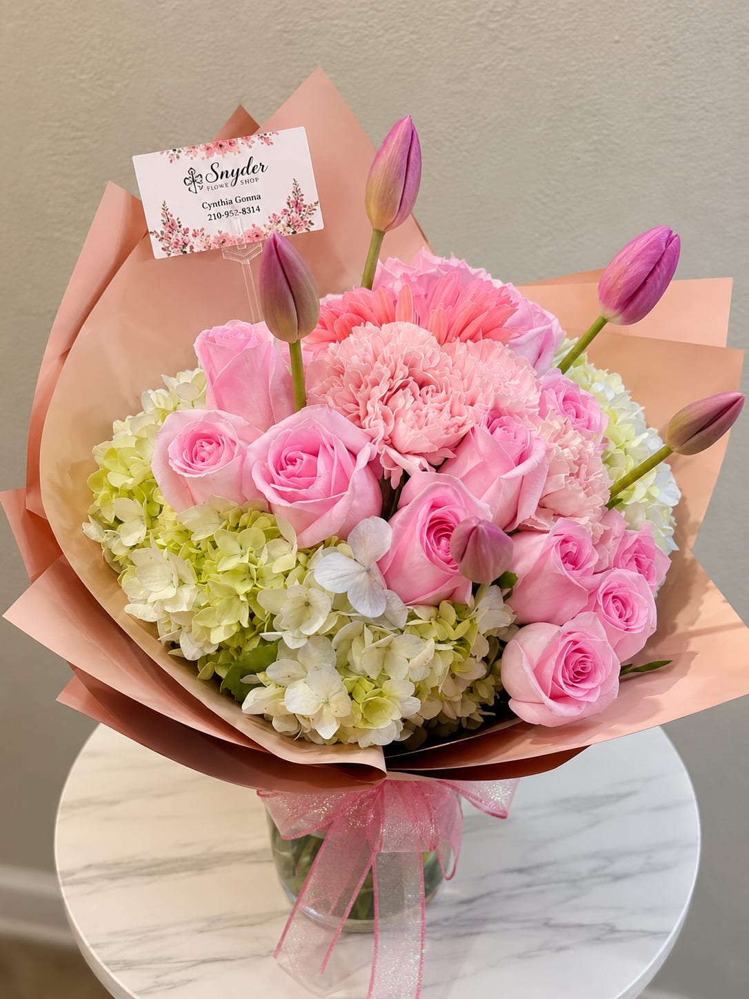 Pink roses and carnations with tulip buds in peach wrapping