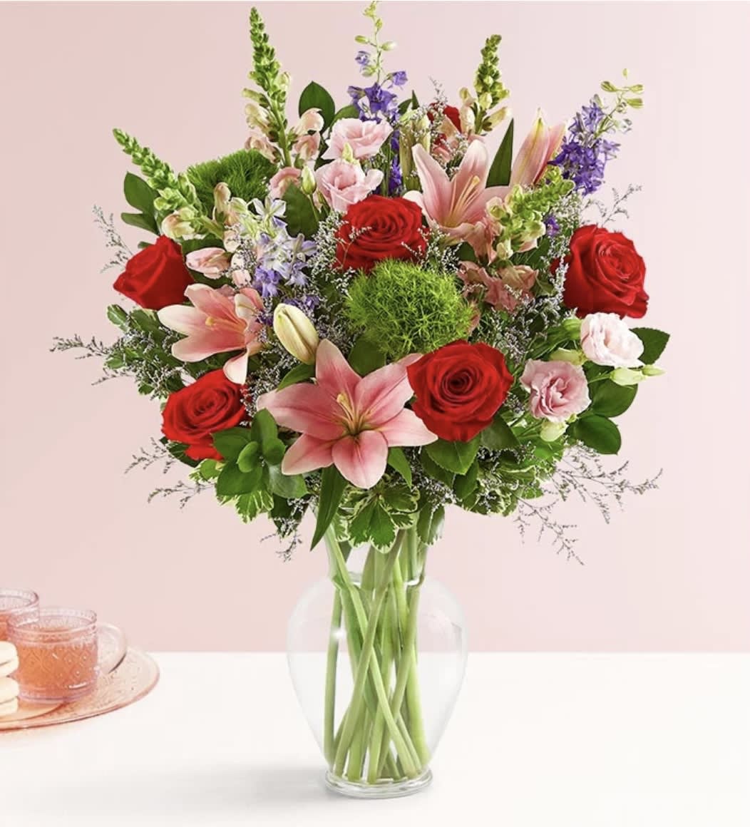 Be Mine™ Bouquet - Description Celebrate Valentine’s with a gift that says, “Be mine!” Our modern-style bouquet is designed with an abundant mix of blooms in sweet, romantic shades. Gathered in a classic clear vase, this blissful surprise delights in every last detail.