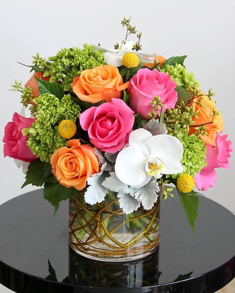 Bouquet of pink, orange, and white roses in a glass vase