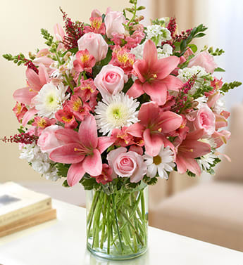  Pink and White - Product ID: 95392   Elegance and grace in abundance mark our pink and white arrangement. The freshest roses, snapdragons, lilies, alstroemeria, stock and more are gathered by hand in a classic cylinder vase . Lush bouquet of the freshest pink roses, snapdragons, lilies, alstroemeria and heather, paired with white cremones and stock and accented with variegated pittosporum, salal and myrtle Hand-designed by our expert florists in a classic glass cylinder vase; vase measures 8"H Can be sent to the home of friends, family members or business associates, or to the funeral service Large arrangement measures approximately 24"H x 22"L Medium arrangement measures approximately 22"H x 20"L Small arrangement measures approximately 20"H x 18"L Our florists hand-design each arrangement, so colors, varieties, and container may vary due to local availability Lilies may arrive in bud form and will open to full beauty over the next 2-3 days