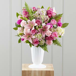 Pink mixed flower arrangement in a white vase