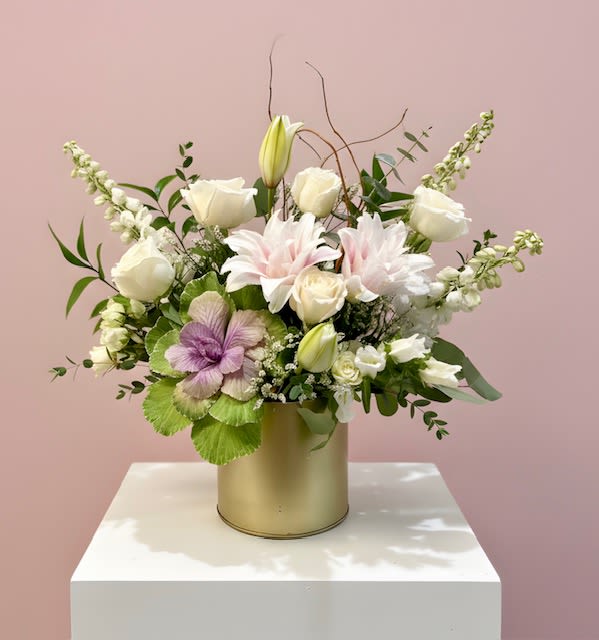 Mixed white and pale pink flowers arranged in a gold cylindrical vase