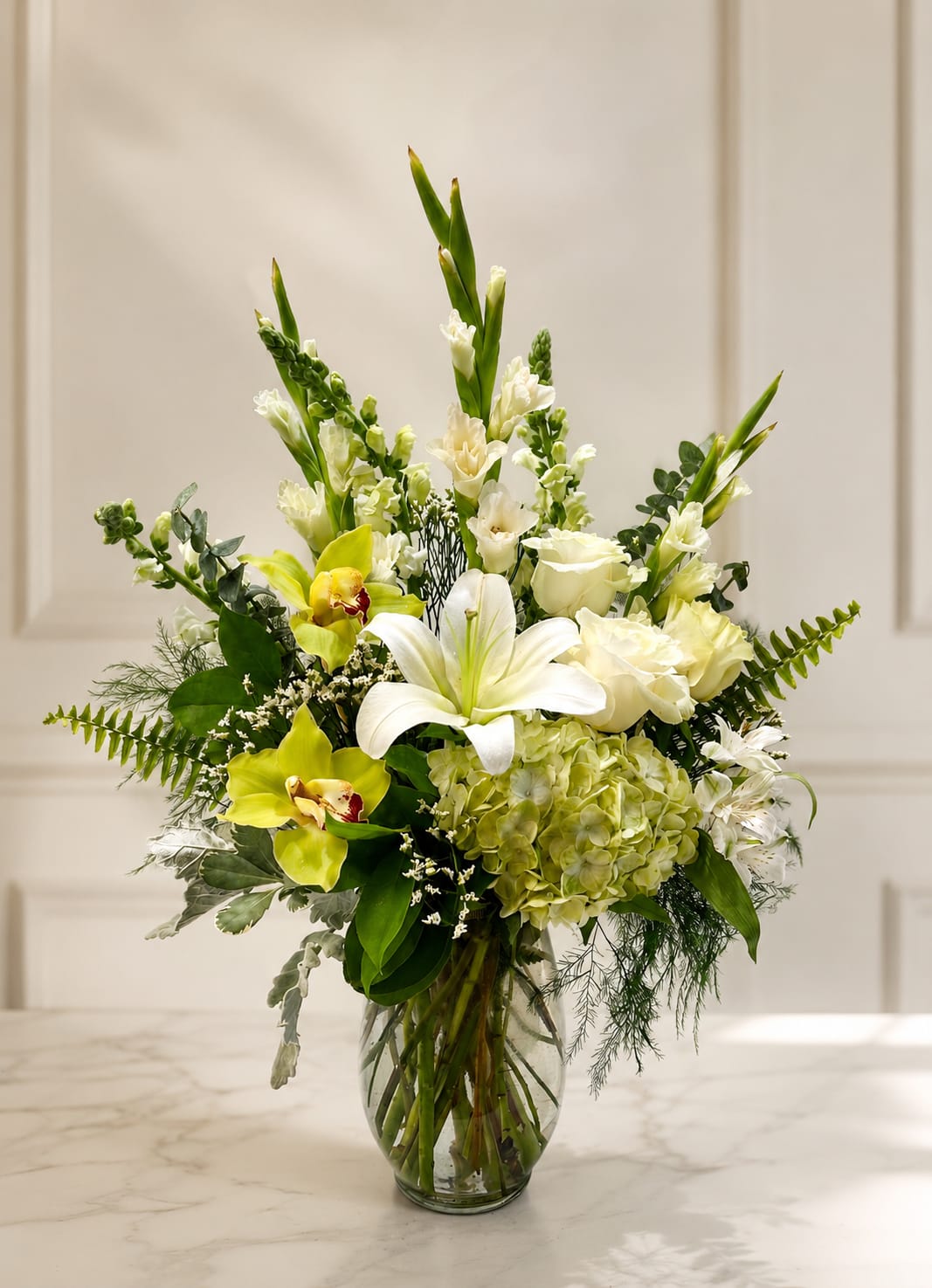 White and green floral arrangement in a glass vase