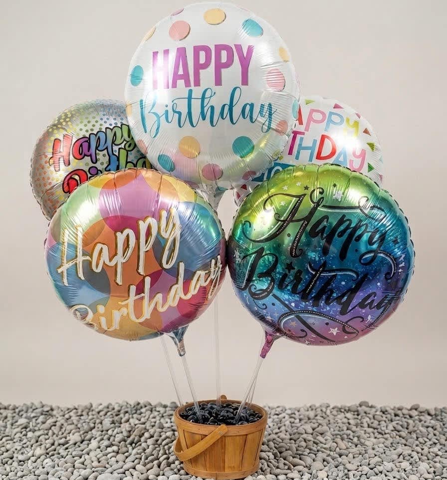 Cluster of birthday balloons in a wooden basket
