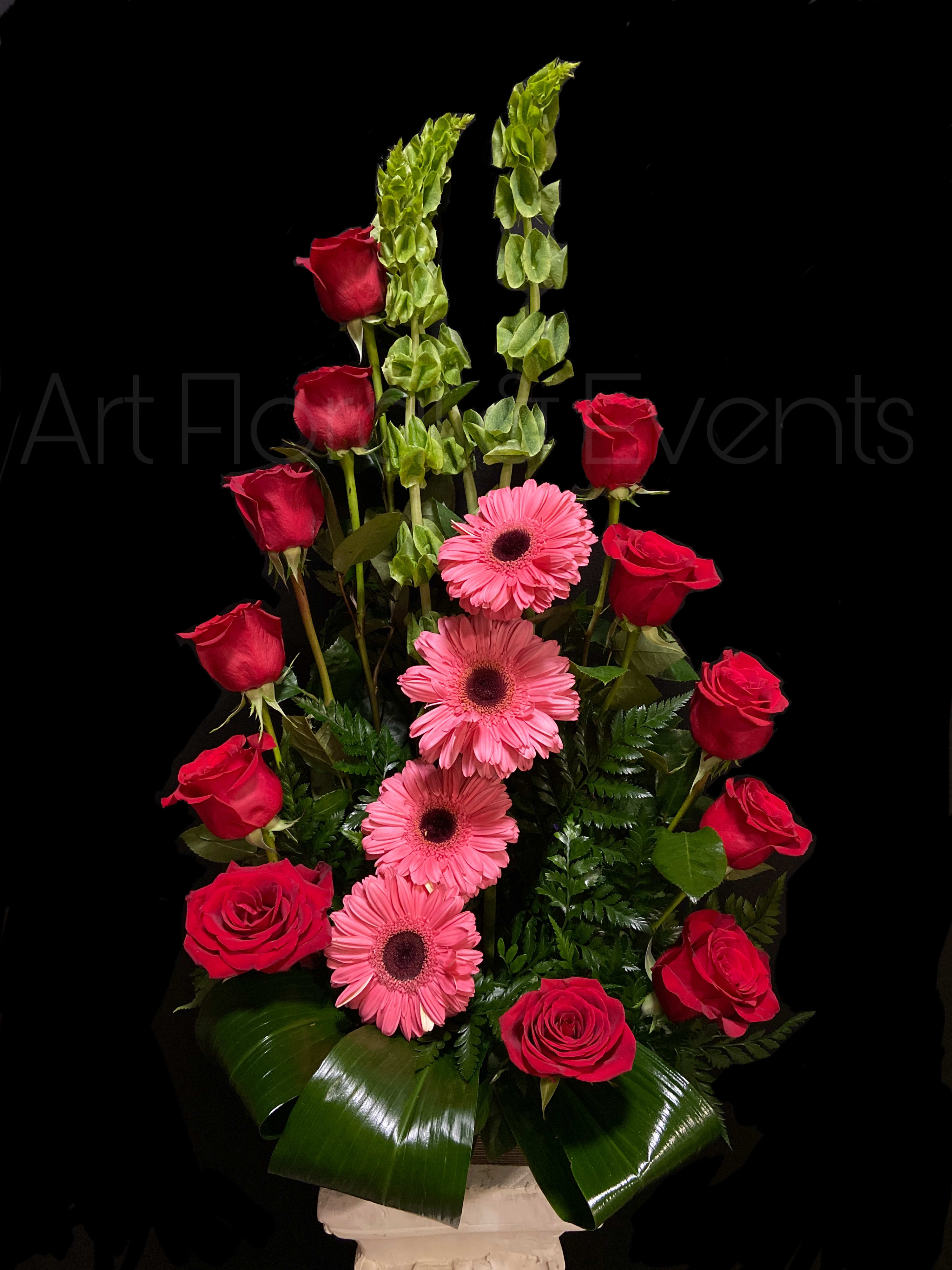 Red roses and pink gerbera daisies in a tall arrangement