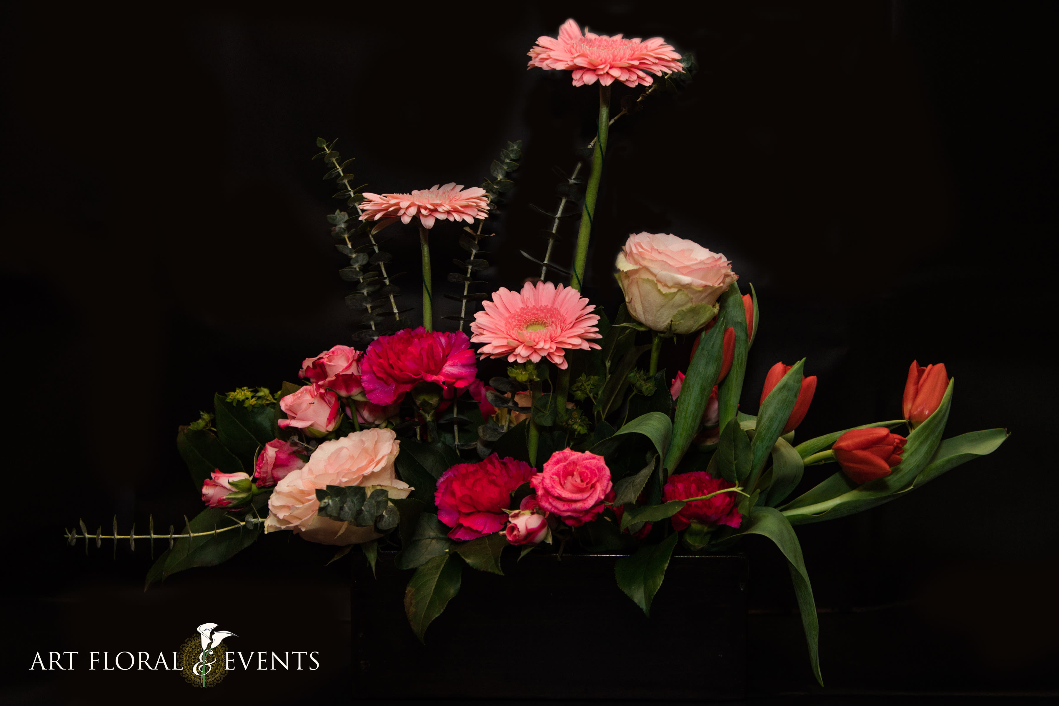 Pink and red mixed flower arrangement with tulips and roses