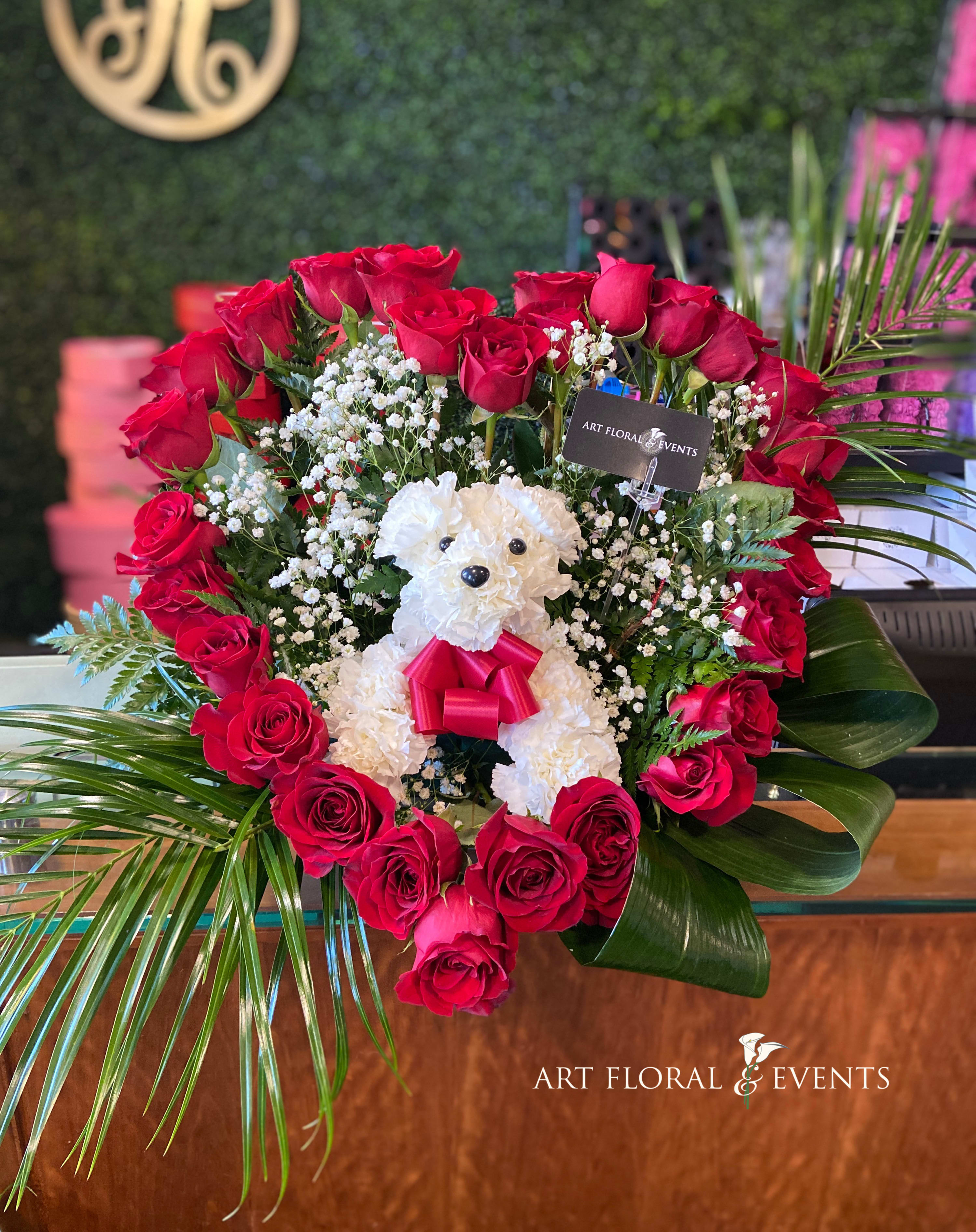 Heart-shaped rose arrangement with a white teddy bear in the center