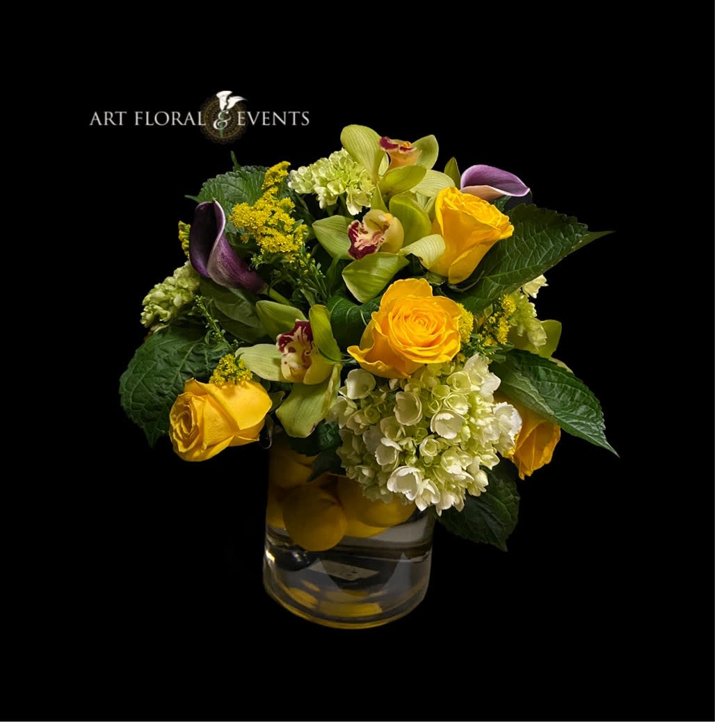 Yellow roses and orchids in a glass vase