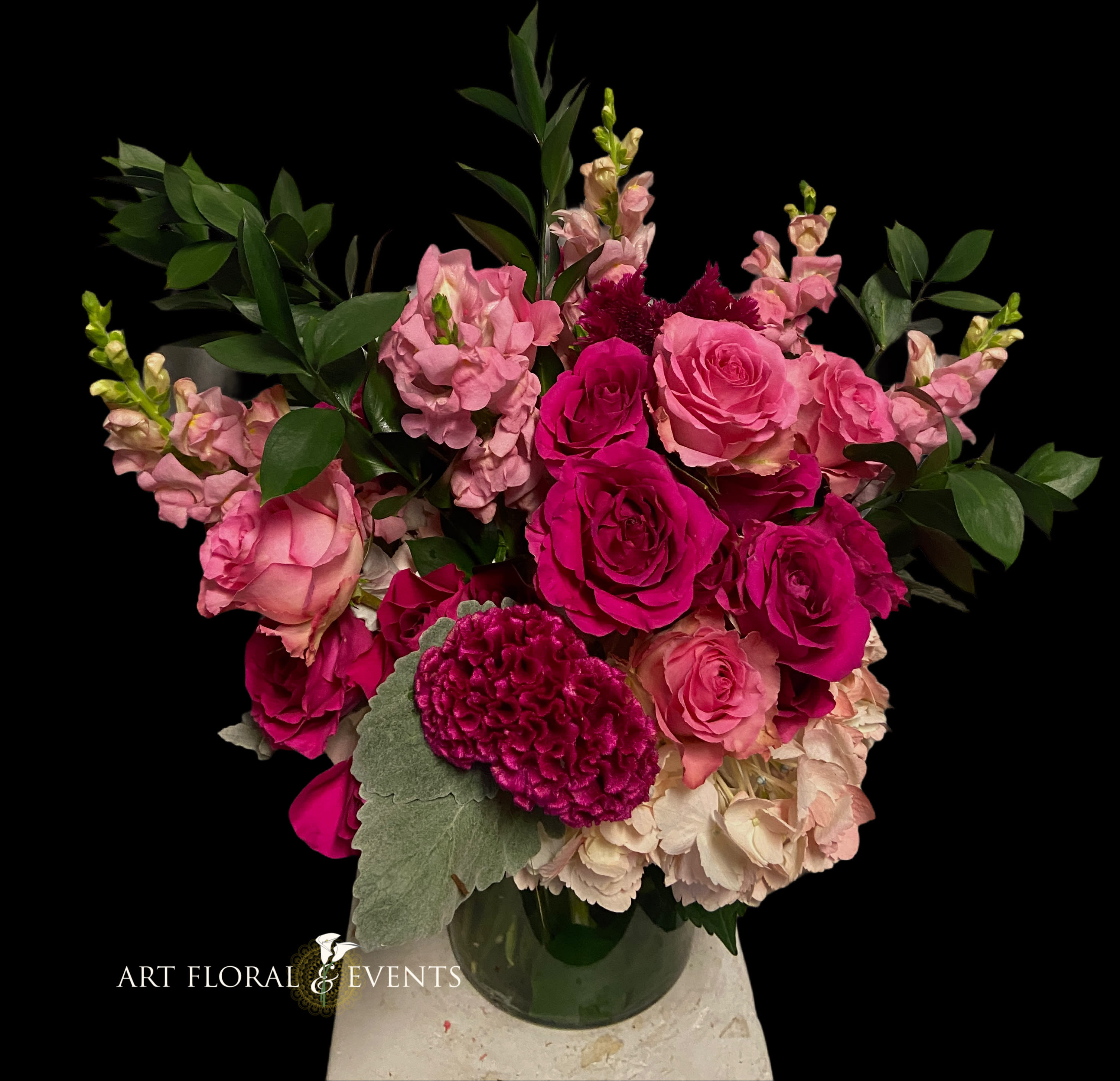 Pink rose bouquet with snapdragons and greenery in a glass vase