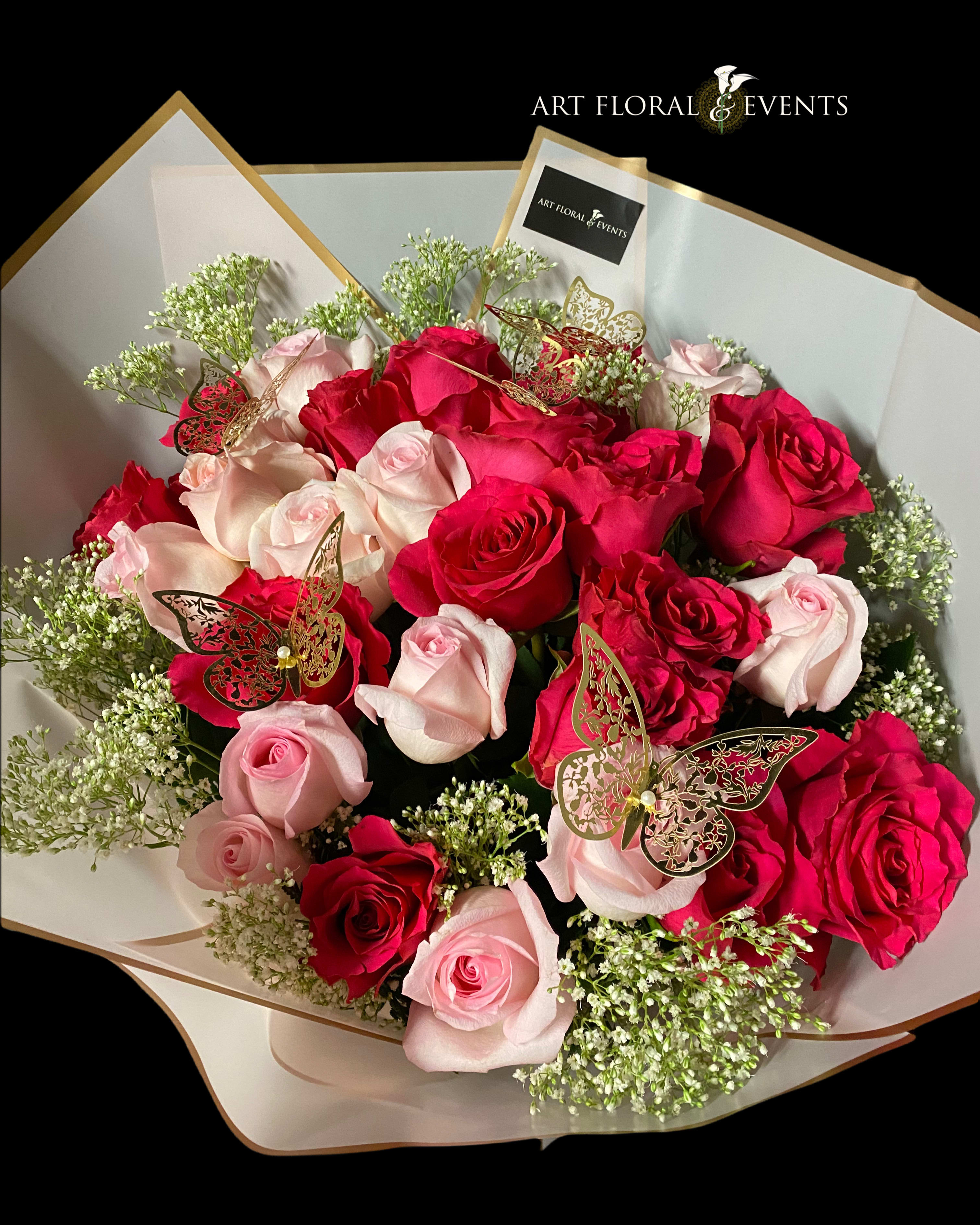 Bouquet of red and pale pink roses with butterfly picks