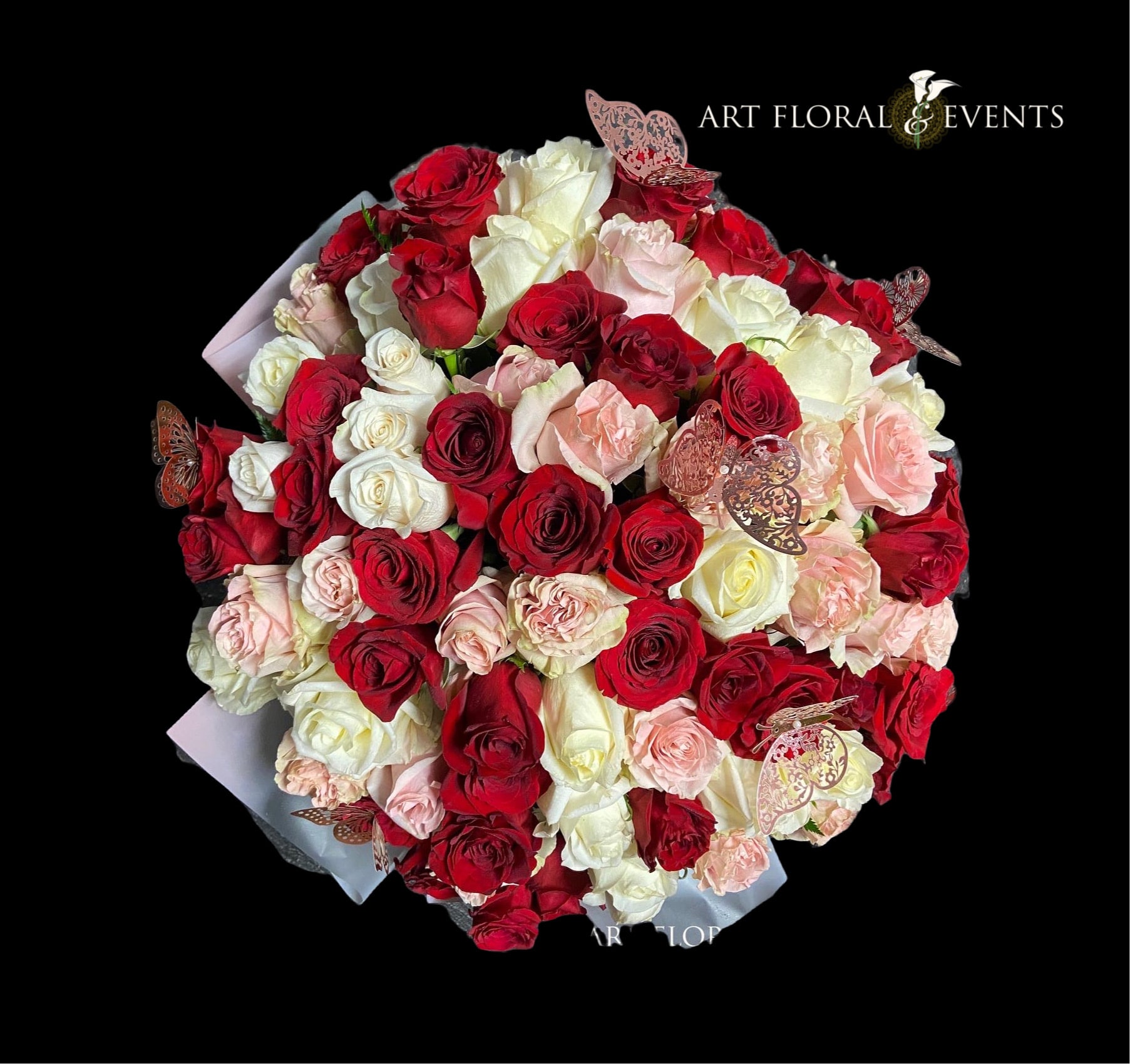 Bouquet of red, white, and blush roses with butterfly accents