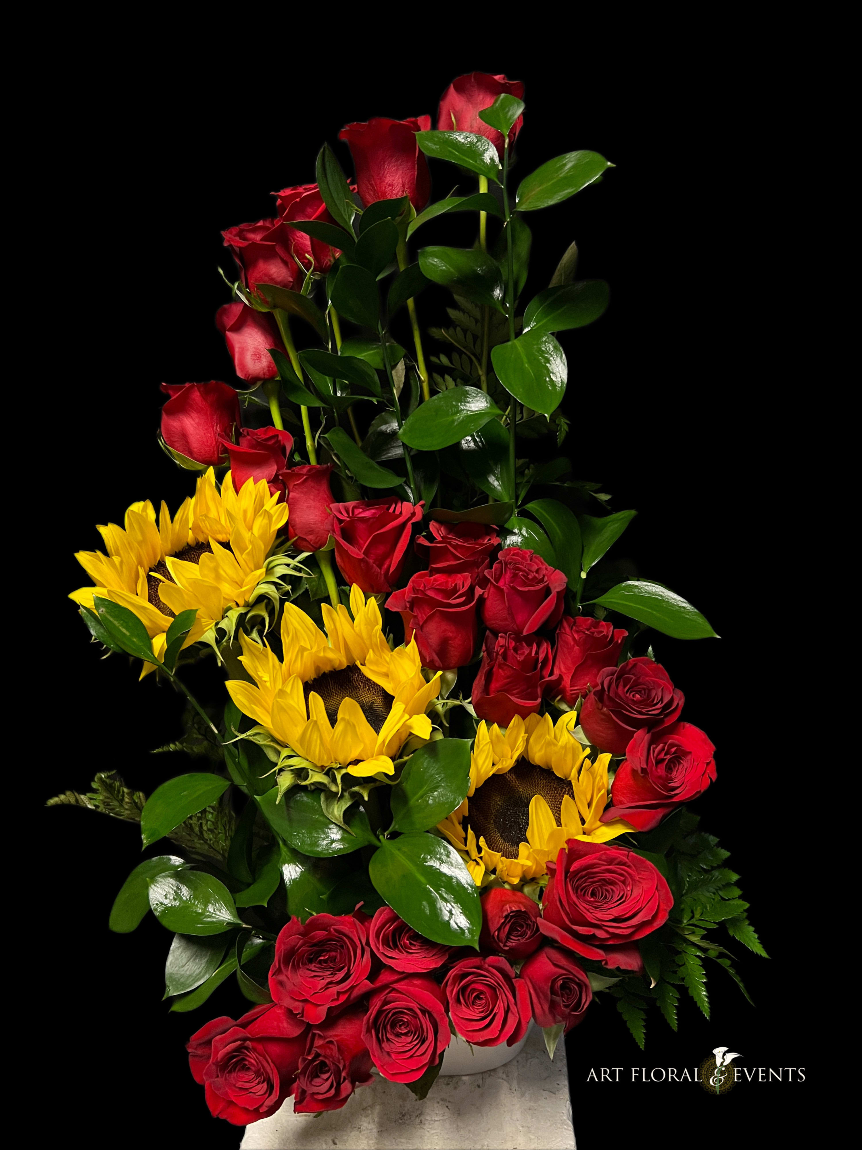 Tall arrangement of red roses and yellow sunflowers in a vase