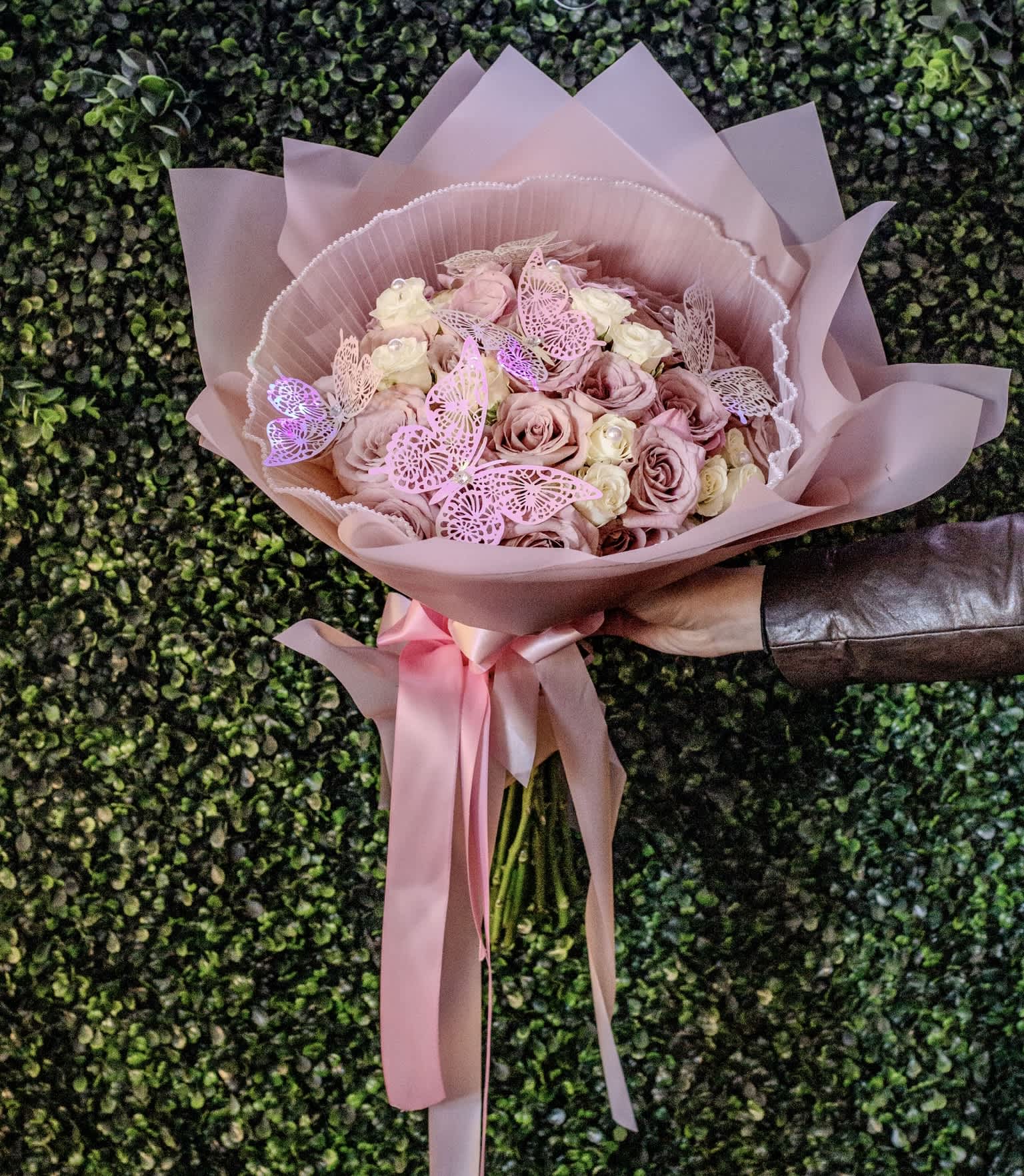 Pink rose bouquet wrapped in blush paper with a satin ribbon
