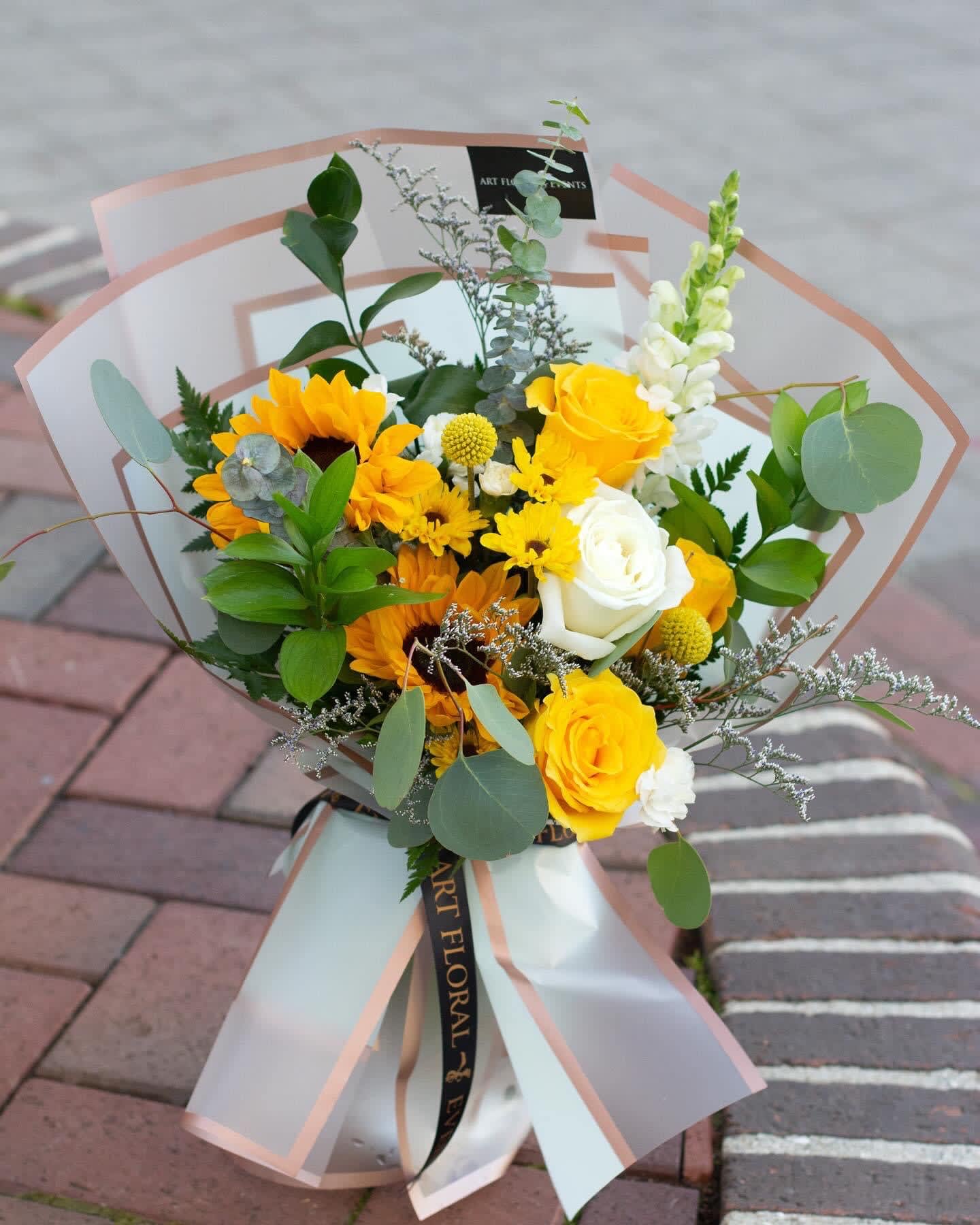 Bouquet of yellow and white flowers wrapped in translucent paper