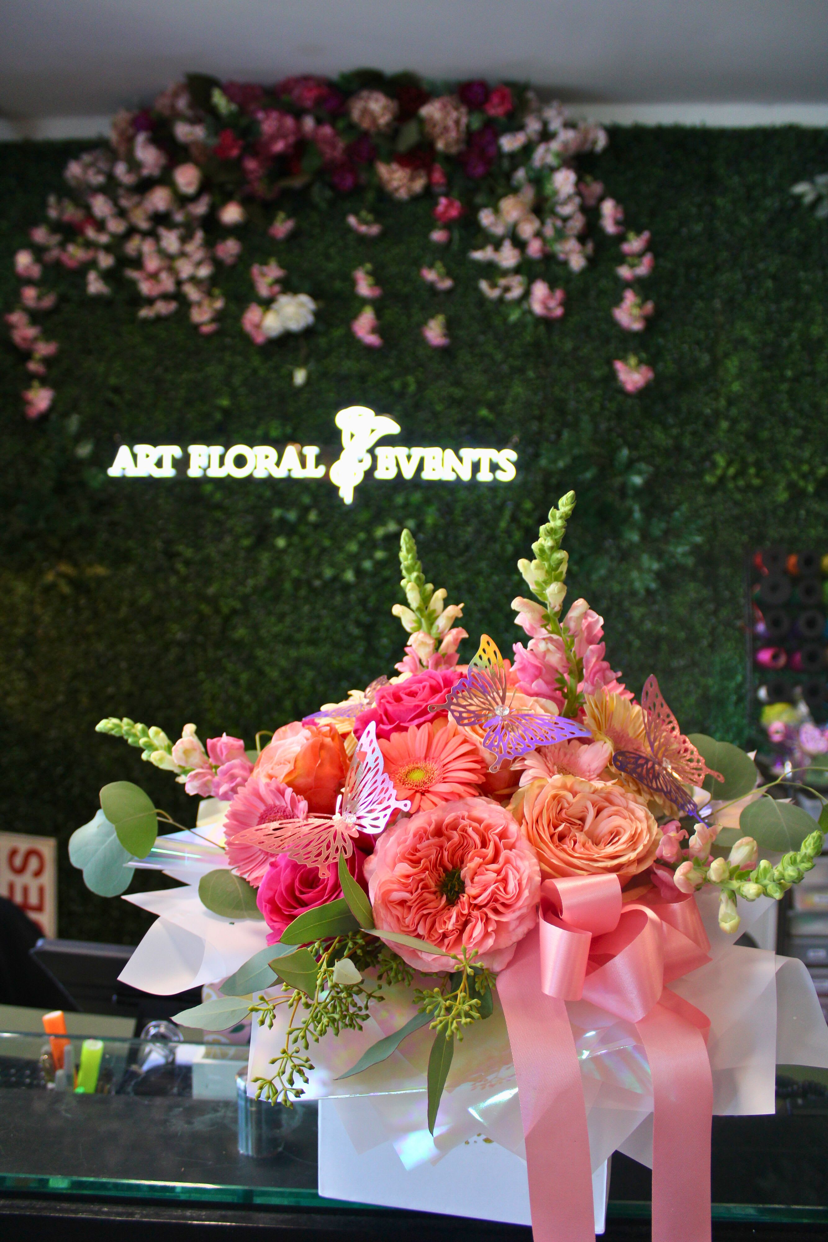 Pink and peach flower bouquet in a white box with a ribbon