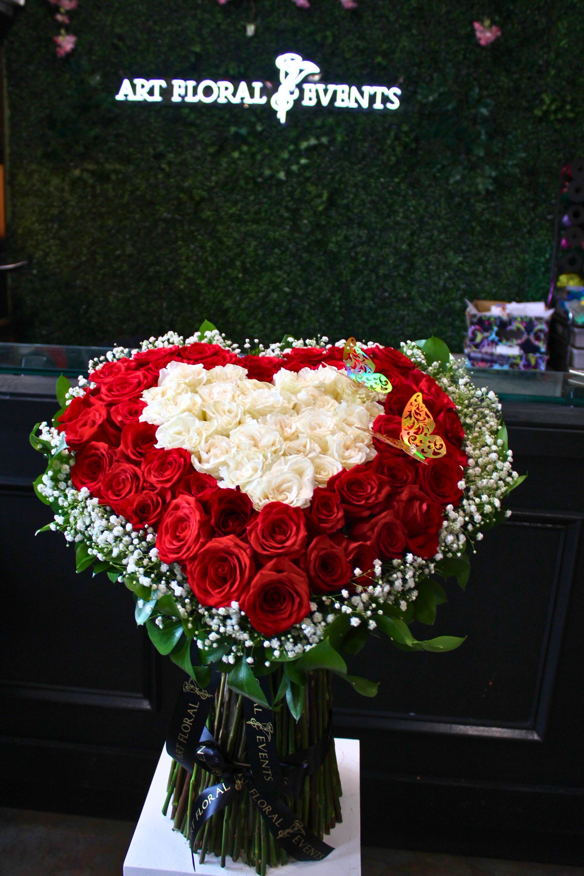 Heart-shaped bouquet of red and white roses with baby’s breath
