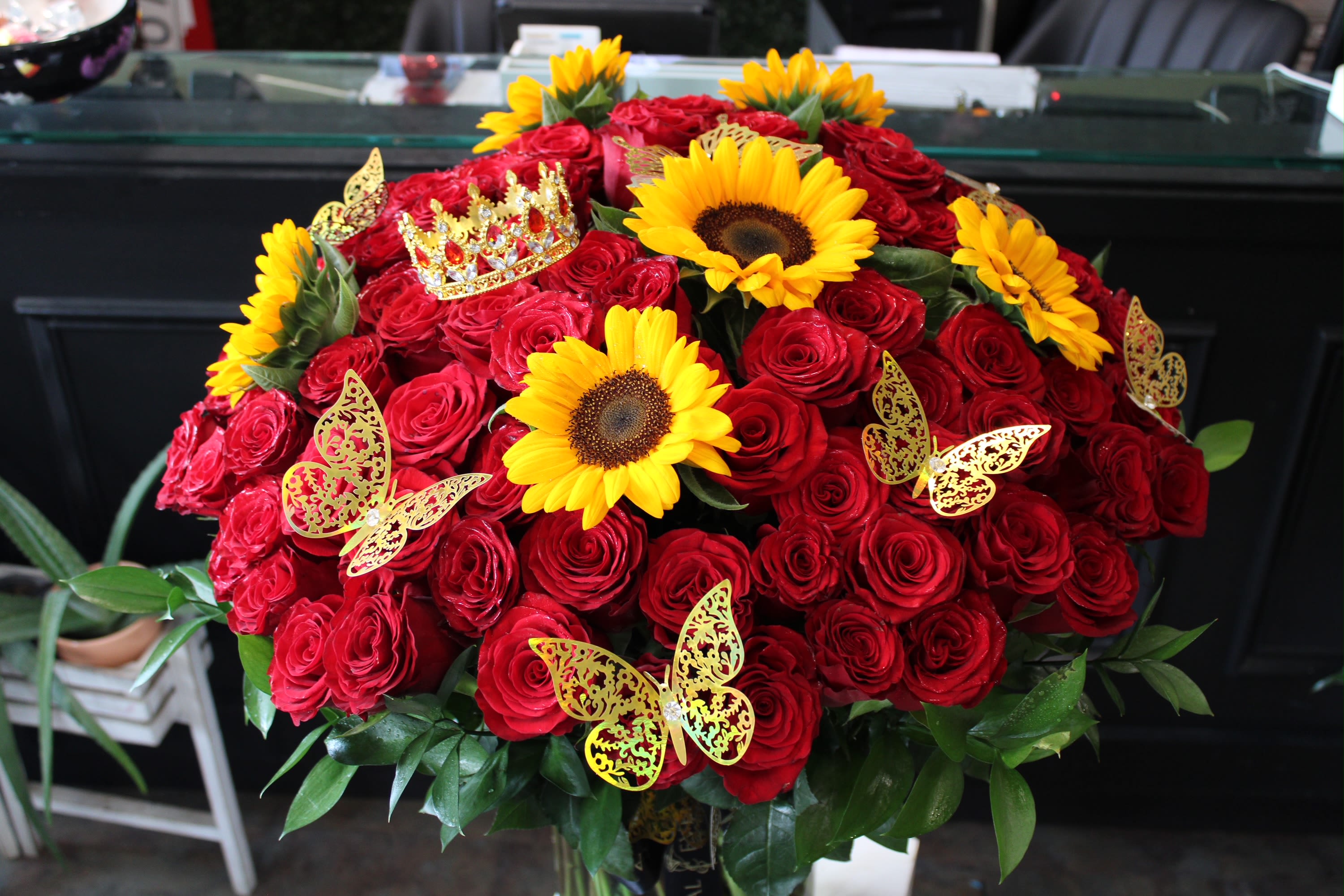 Large bouquet of red roses with yellow sunflowers and butterfly decorations
