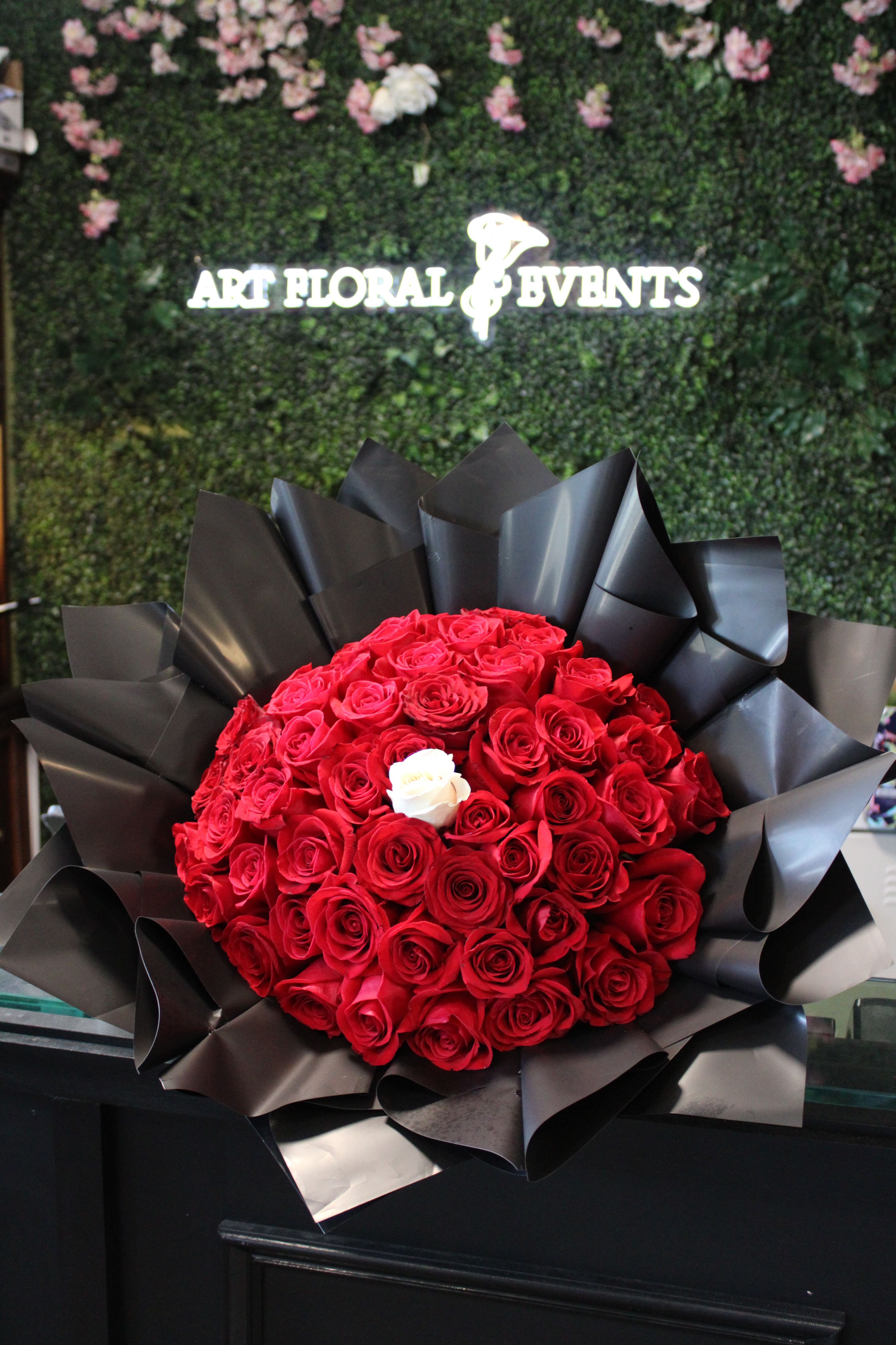 Large bouquet of red roses wrapped in black paper