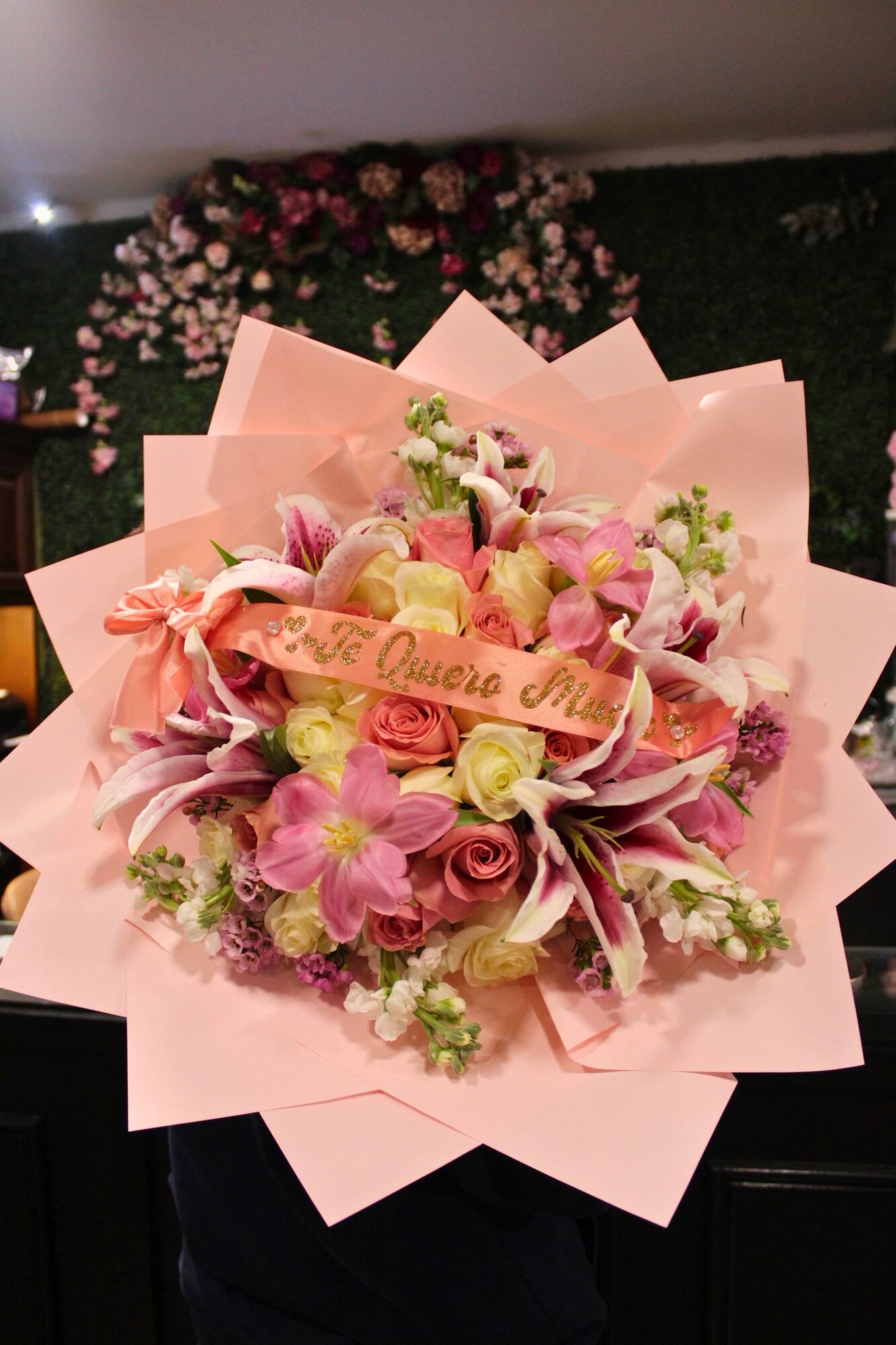 Pink bouquet with roses and lilies wrapped in pastel paper