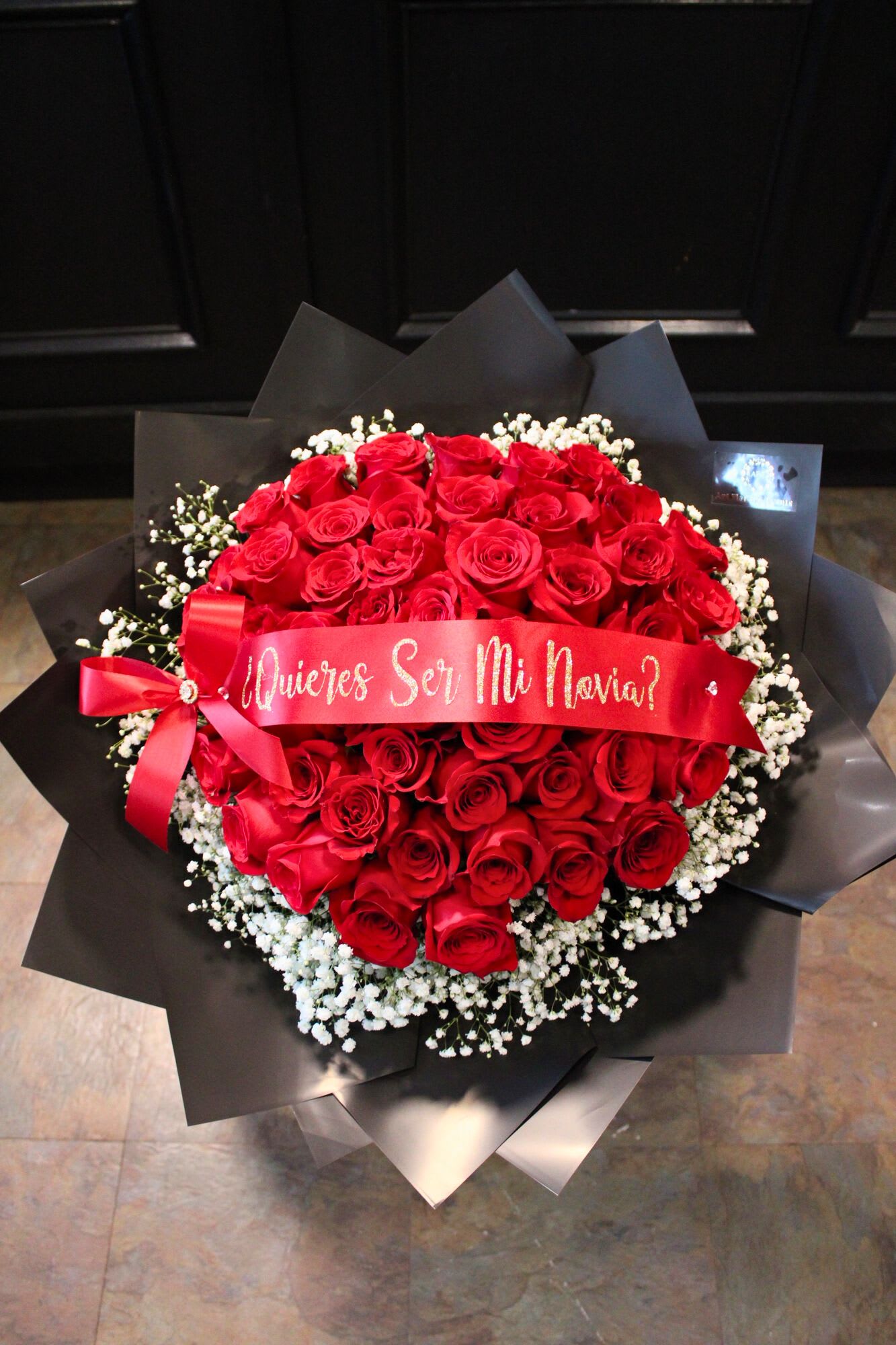 Bouquet of red roses with white baby's breath and a red ribbon