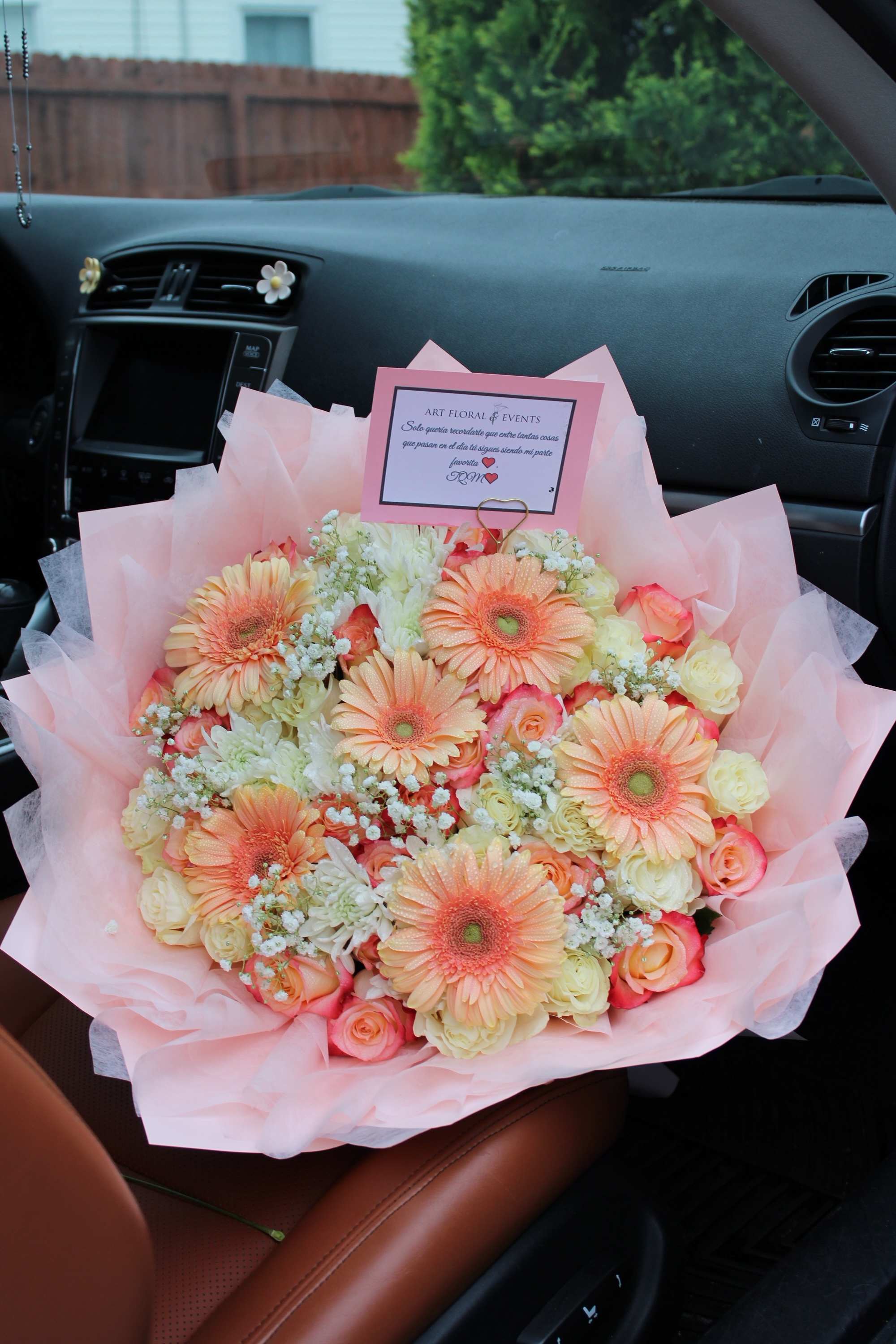 Pink bouquet with peach gerbera daisies and roses in a car seat