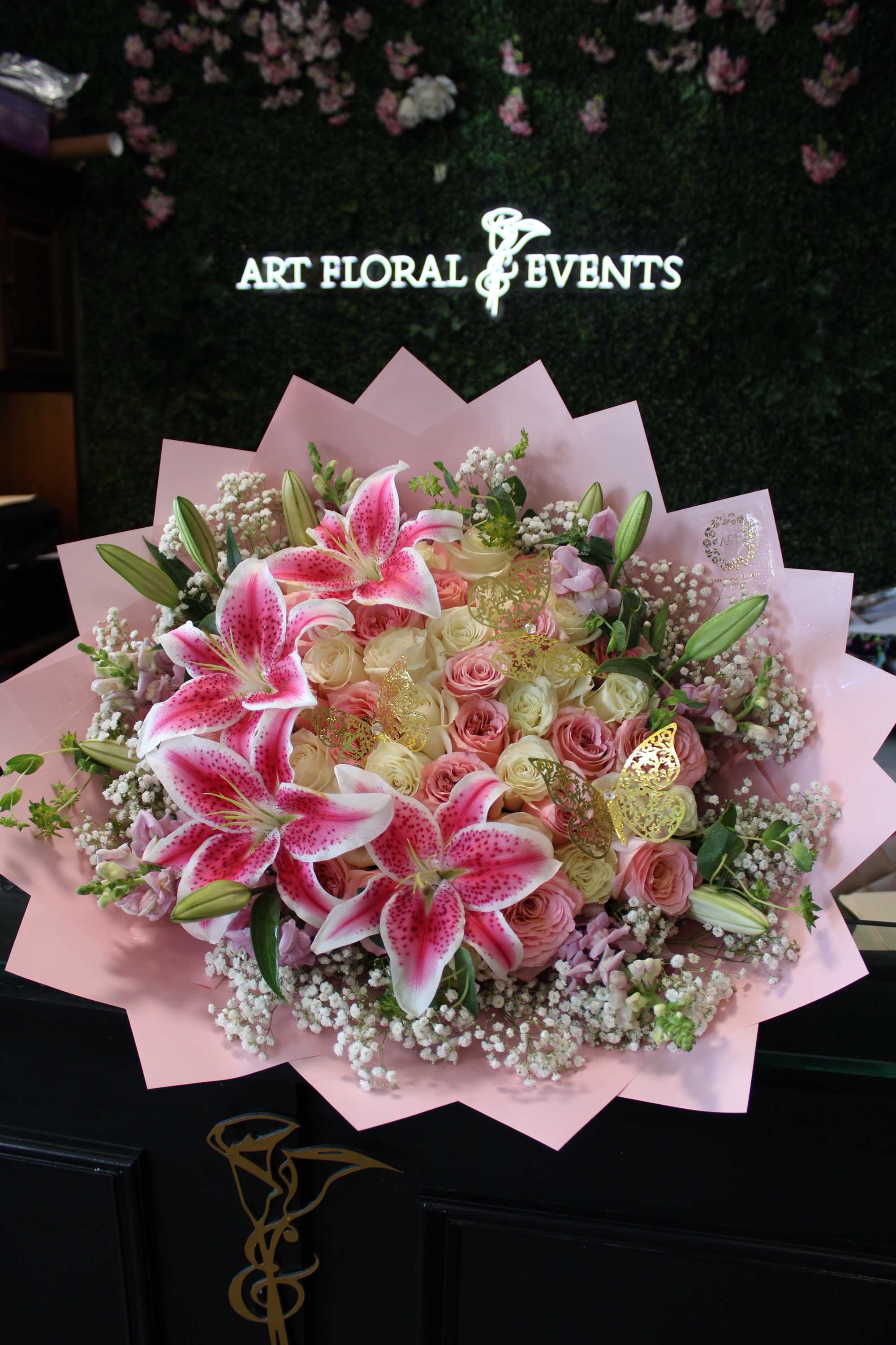 Pink and white bouquet with lilies and roses wrapped in pink paper