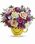 Mixed flower bouquet in a yellow smiley-face mug