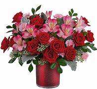 Red roses and pink alstroemeria in a red vase