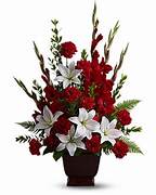 Red and white floral arrangement in a dark vase