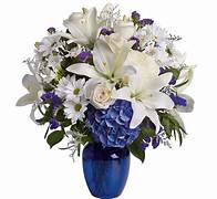 White and purple floral arrangement in a blue vase