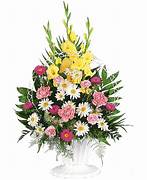 Mixed pink and yellow flower arrangement in a clear vase