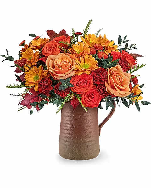 Autumn bouquet of orange roses and yellow daisies in a brown pitcher