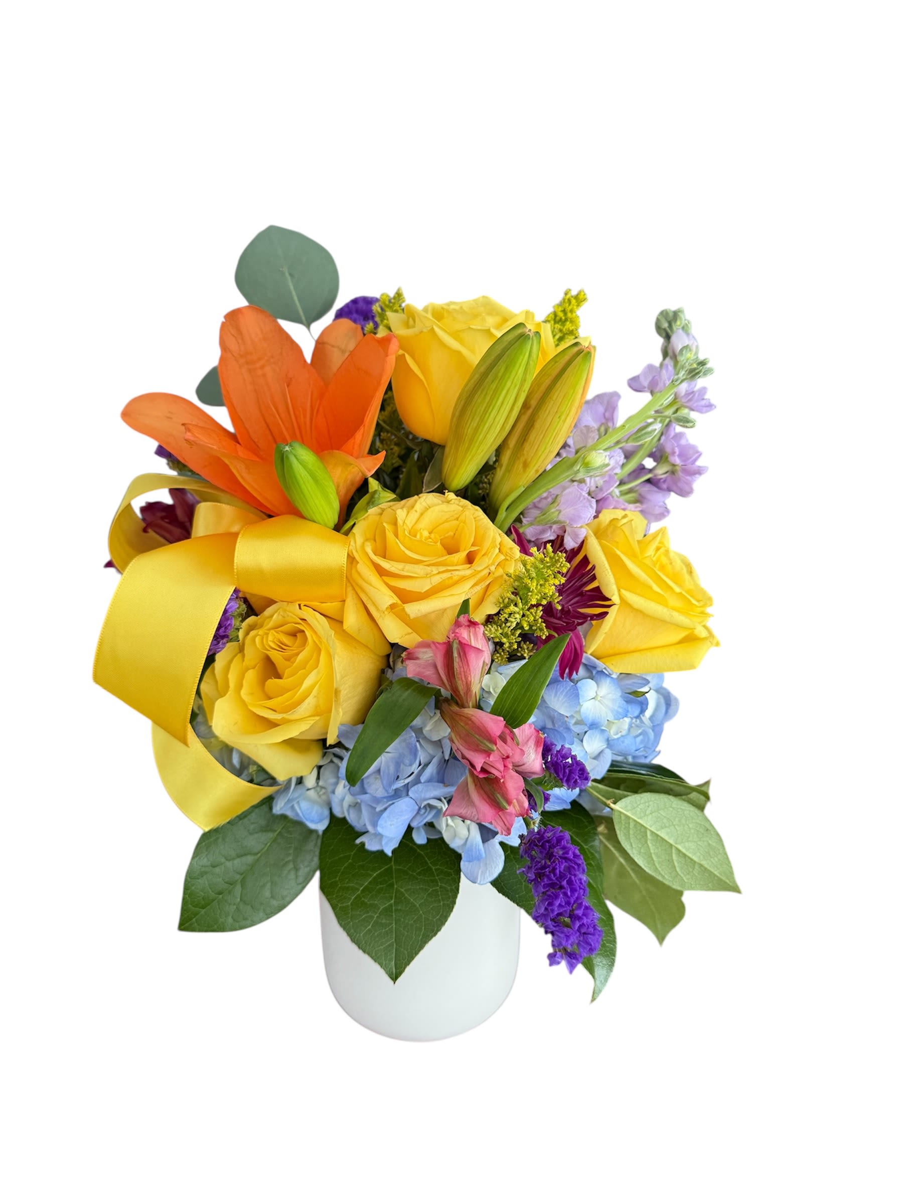 Bouquet of yellow and orange roses with blue hydrangeas in a white vase