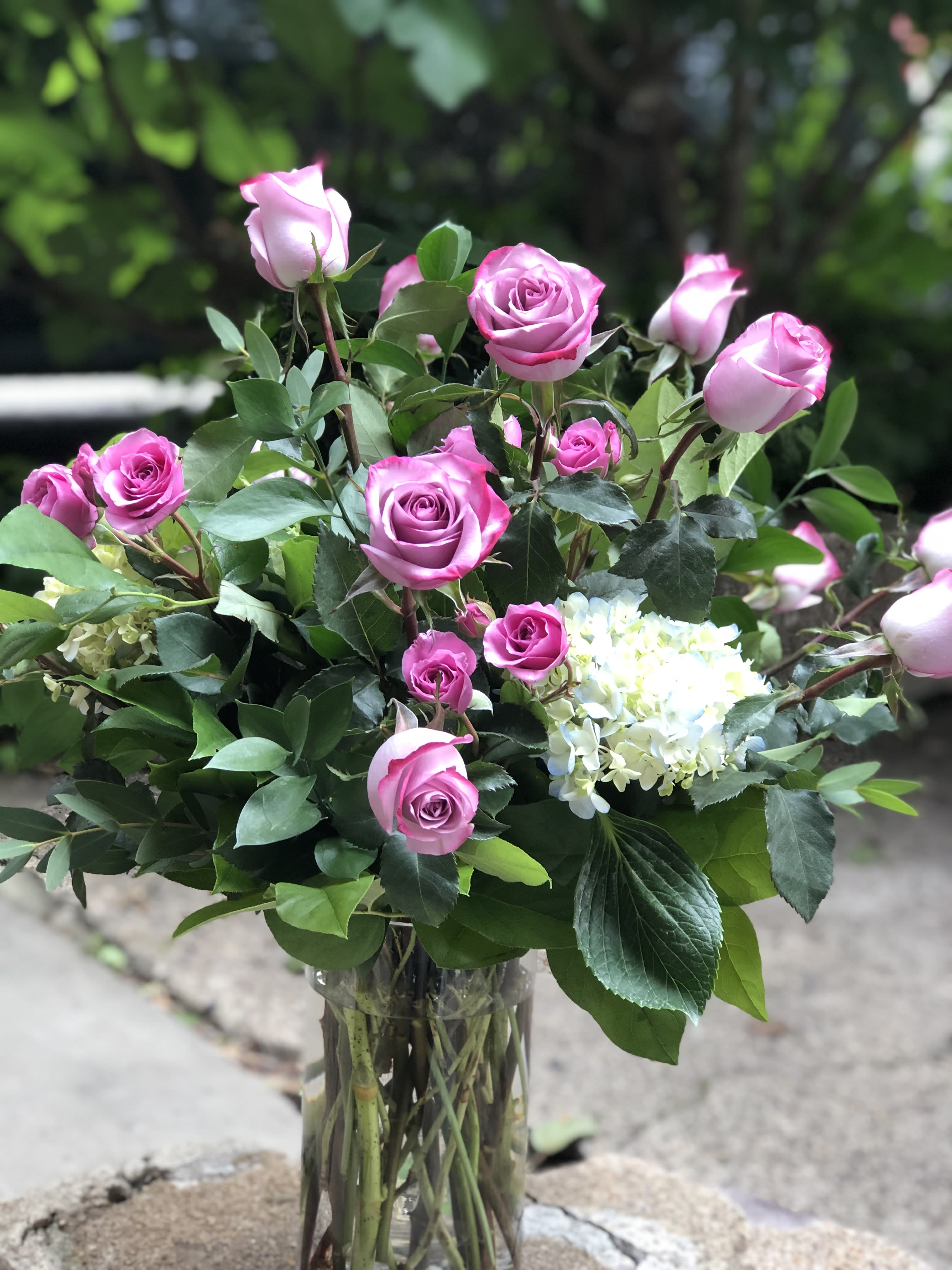 Pink roses and white hydrangea in a clear glass vase