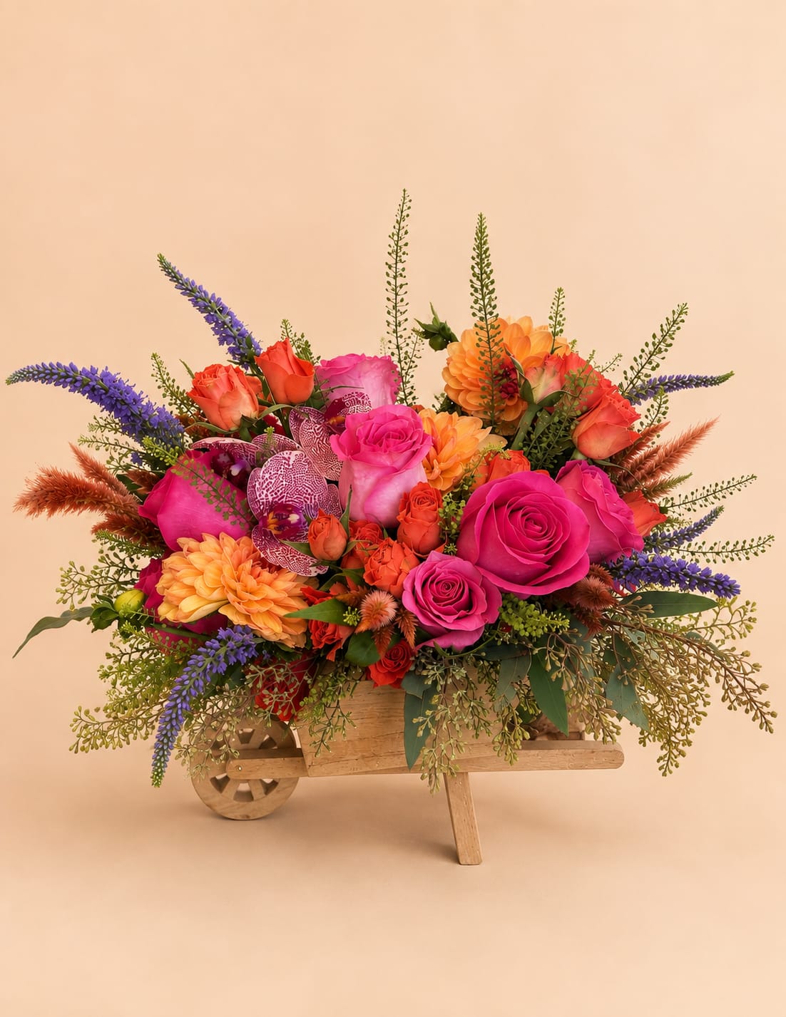 Bright mixed bouquet in a wooden wheelbarrow container