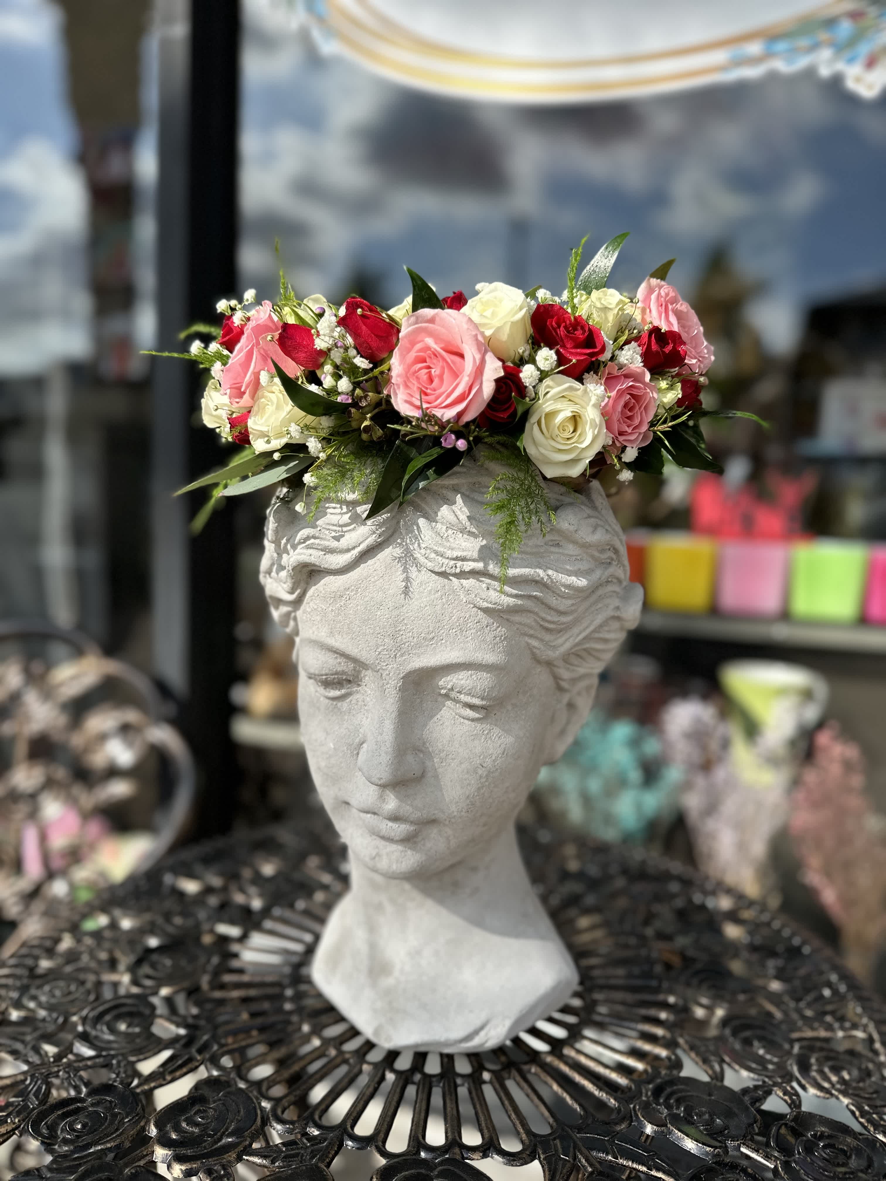 Pink and white rose crown on a stone bust planter