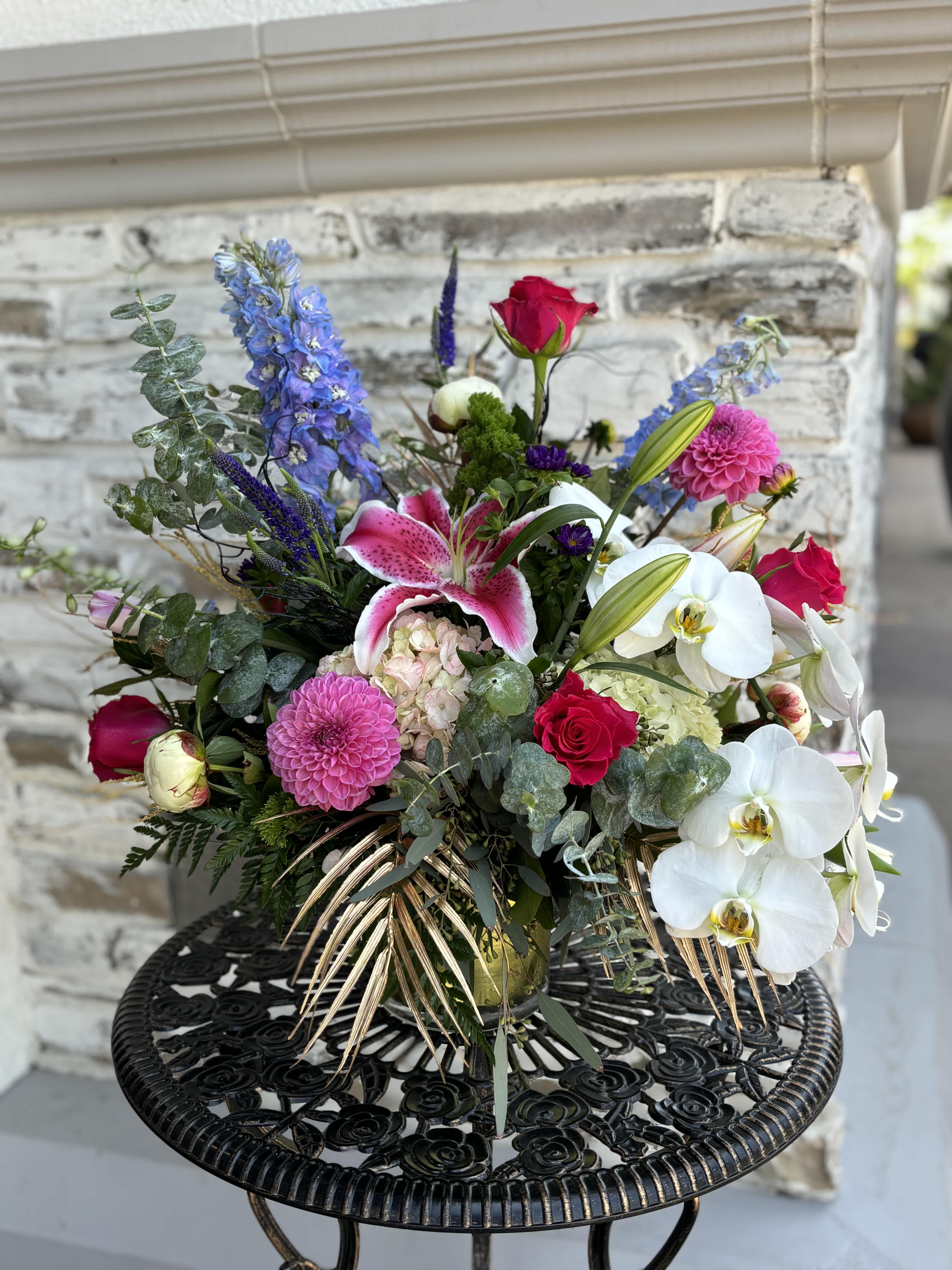 Mixed bouquet with pink roses, white orchids, and a pink lily in a vase
