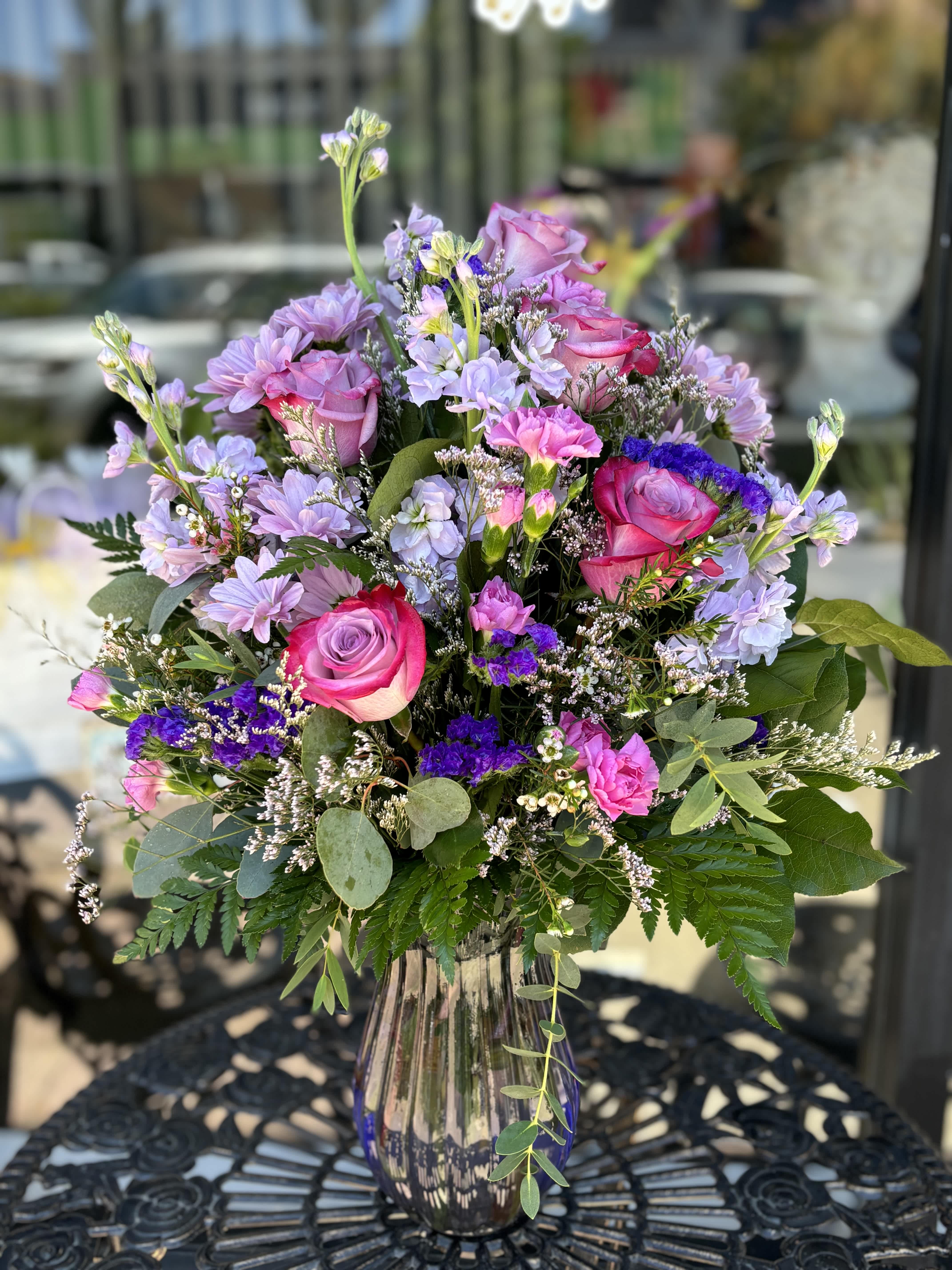 Bouquet of pink roses and lavender flowers in a glass vase