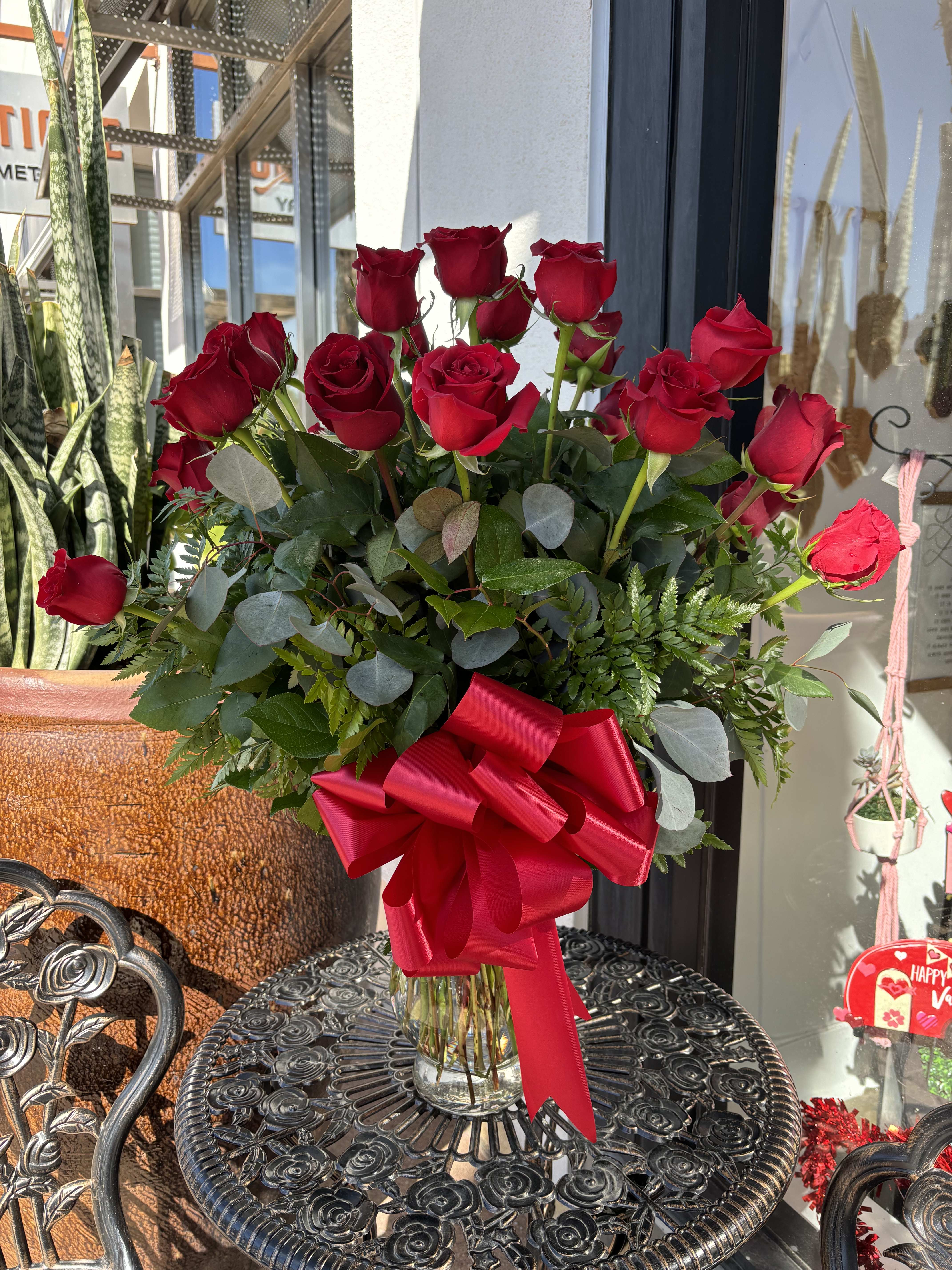 Bouquet of red roses in a glass vase with a red ribbon