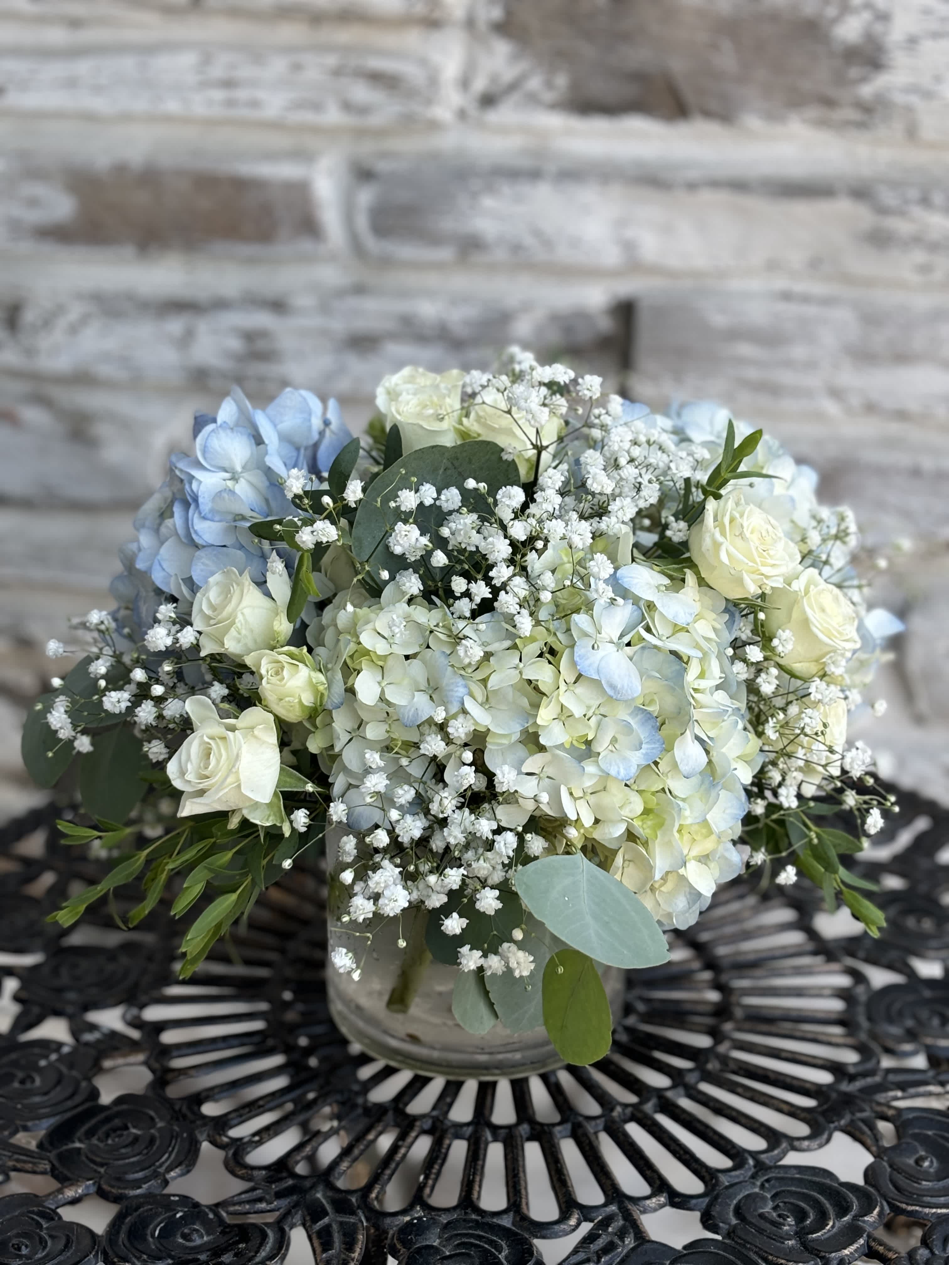 Blue and white floral arrangement in a glass vase