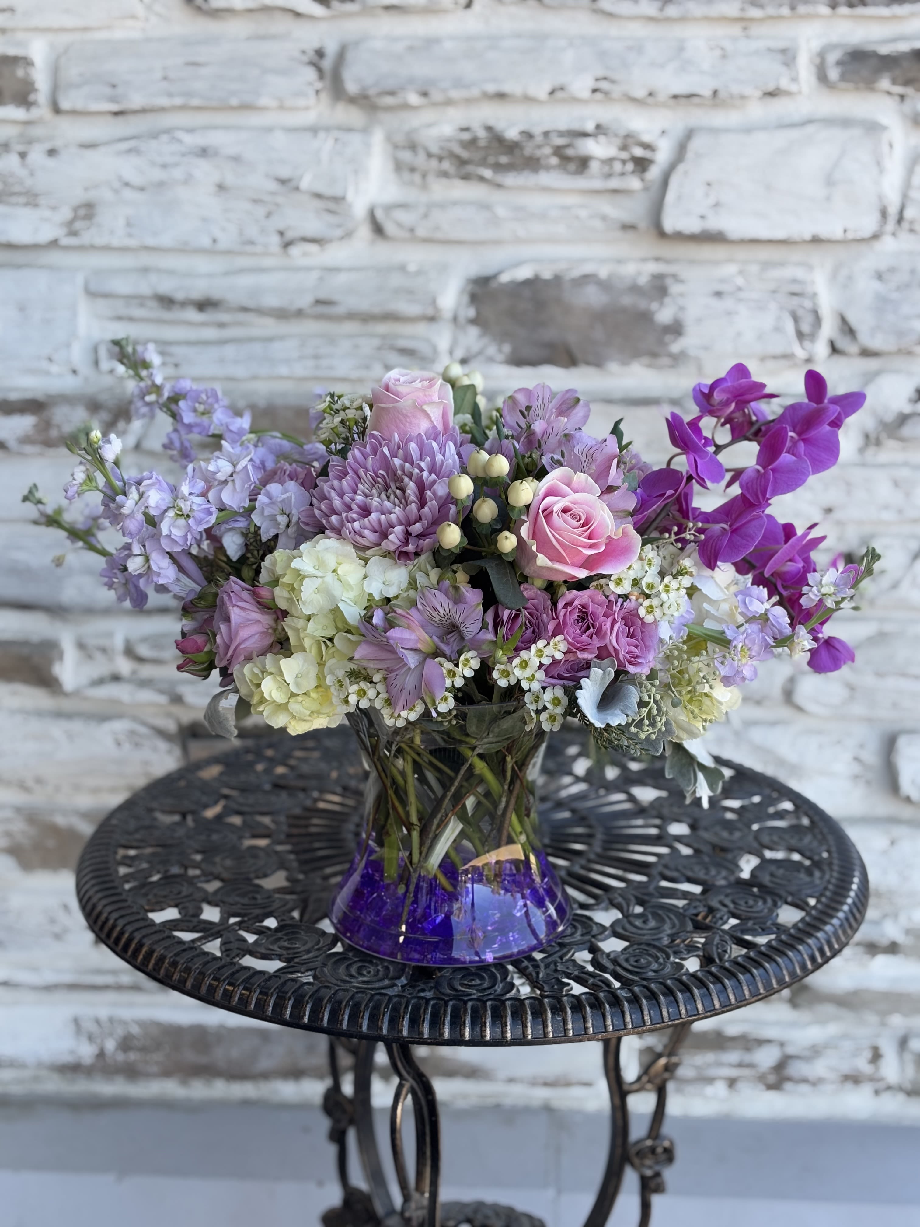 Lavender and pink bouquet in a purple glass vase