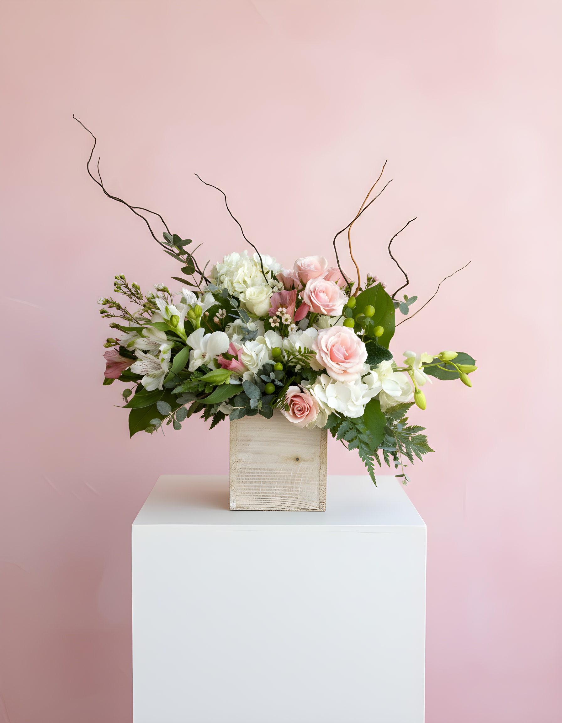 Pink and white floral arrangement in a wooden box