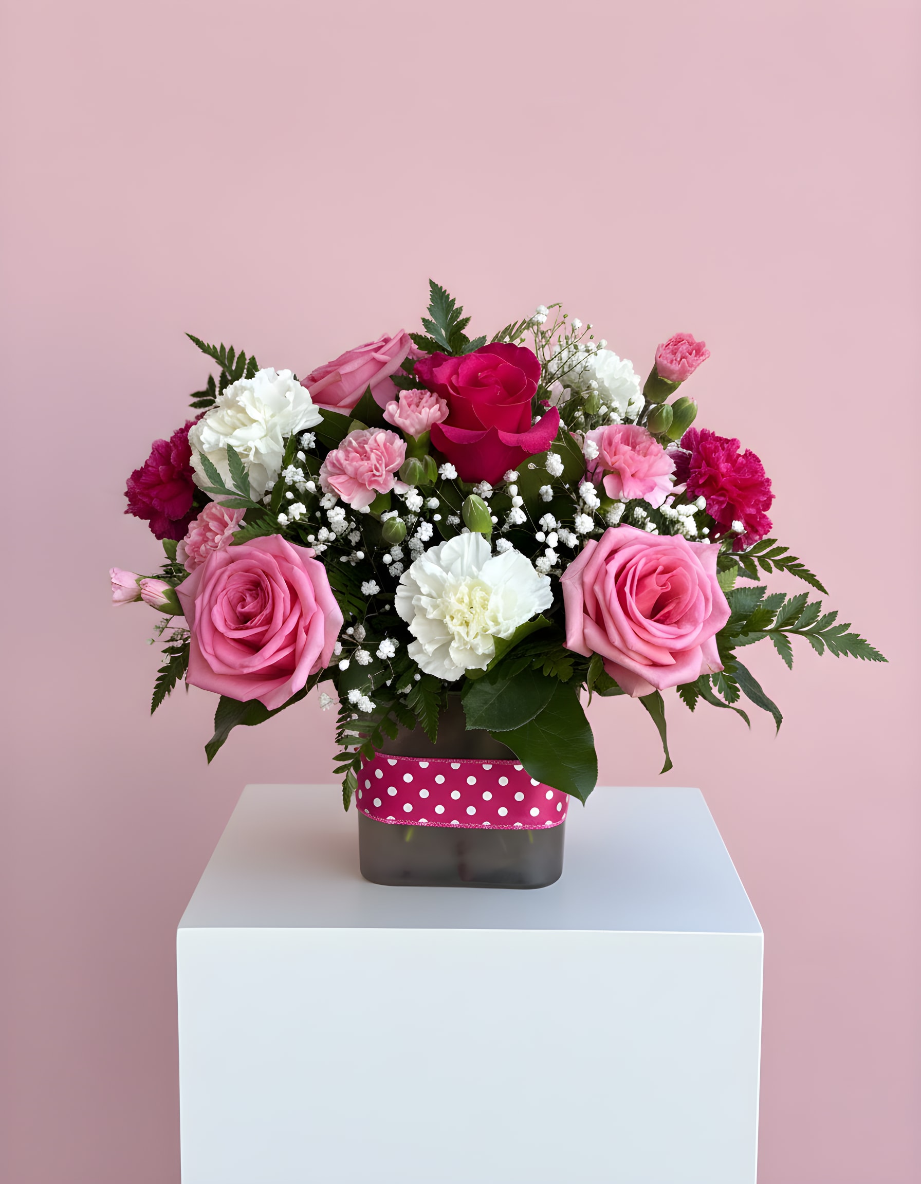 Polka Dot Pink - This beautiful bouquet features pink roses with pink and white carnations arranged in a gorgeous pink cube wrapped with a pink ribbon. Send this bouquet as a thoughtful gift.
