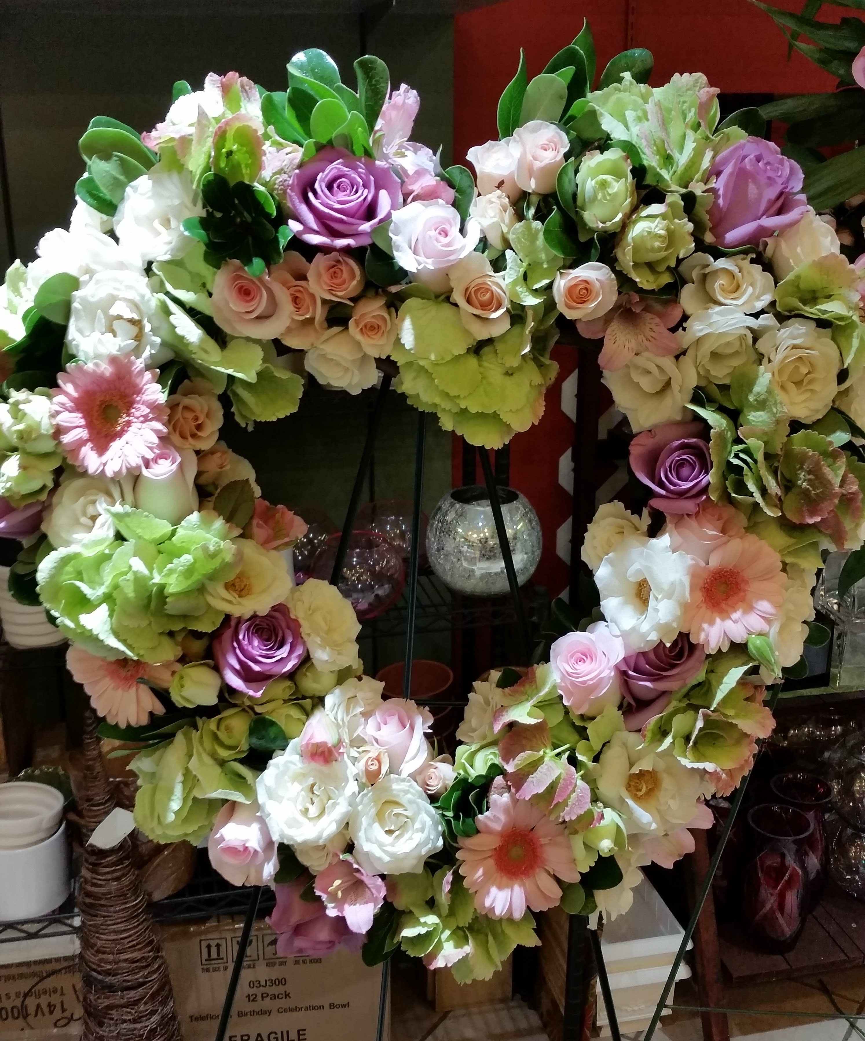 Heart-shaped floral wreath with pastel roses and gerbera daisies